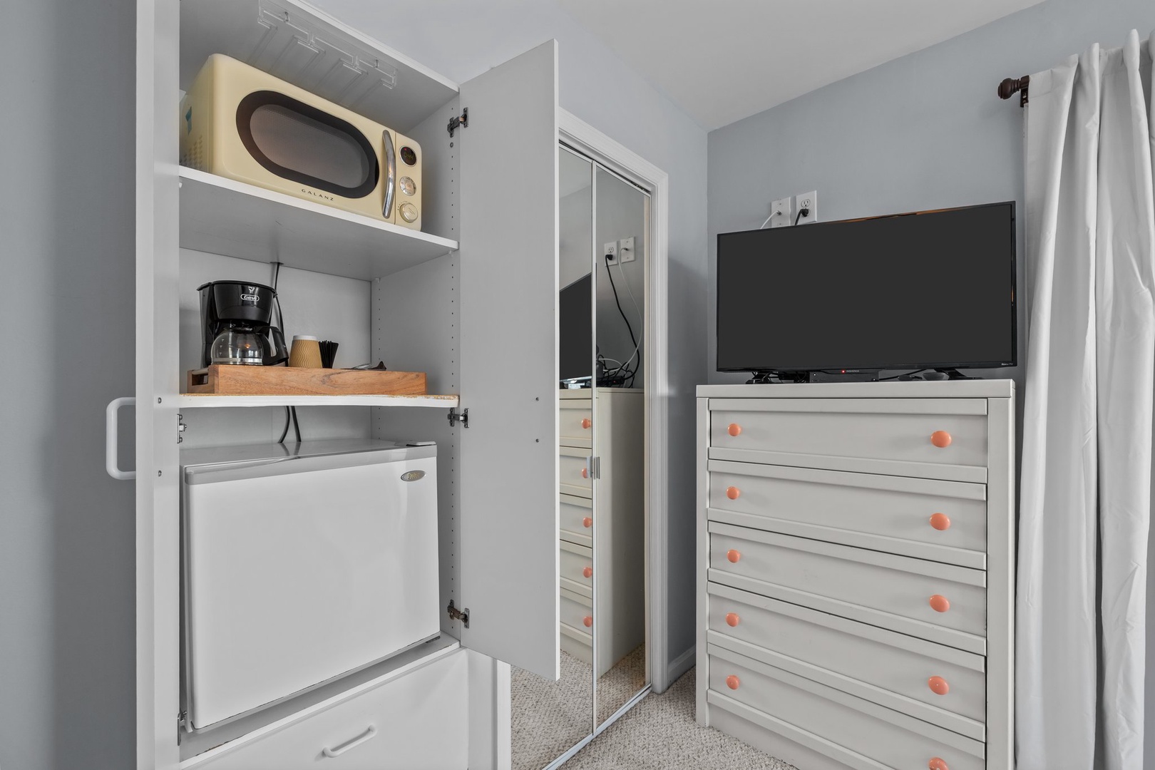 Your compact kitchenette features everything you need—microwave, coffee maker, mini fridge, and entertainment setup for cozy meals and relaxation.