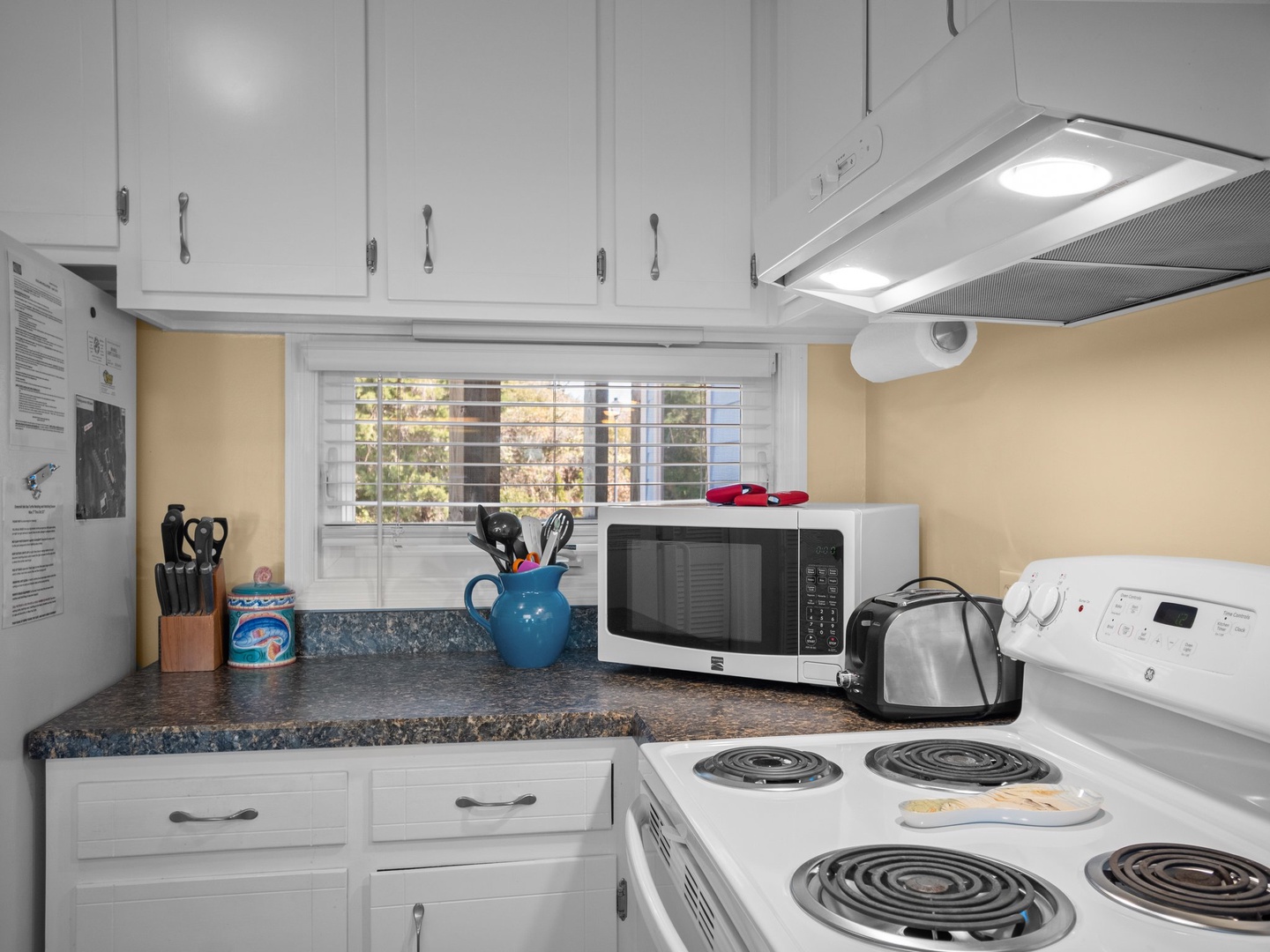 Your fully-equipped kitchen awaits with everything you need to prepare meals, featuring a microwave, stove, and plenty of counter space for cooking.