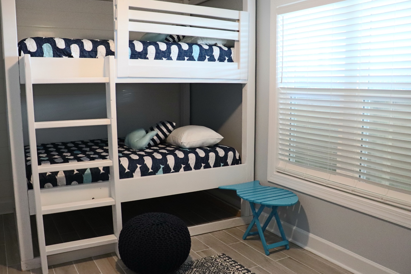 Your kids will love these cozy built-in bunk beds with playful whale-print bedding and natural light streaming through the window blinds.