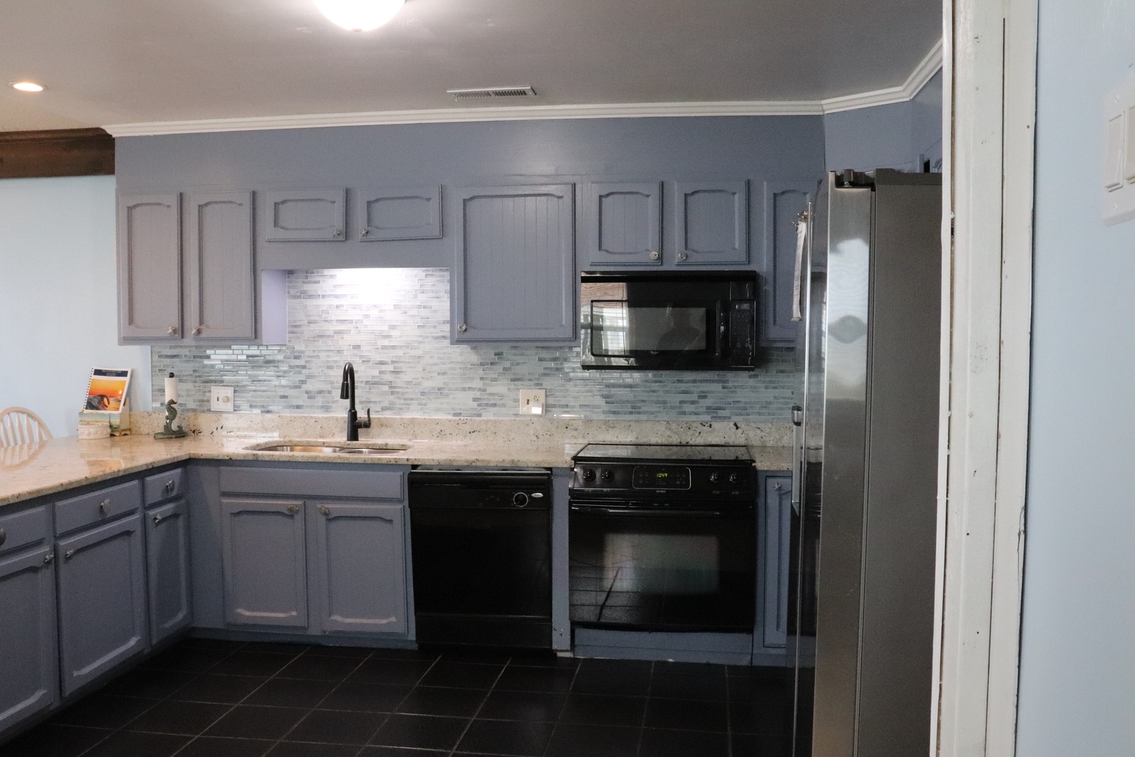 Your full kitchen awaits with granite counters, modern appliances, and stylish gray cabinetry—perfect for preparing meals or enjoying morning coffee at your leisure.