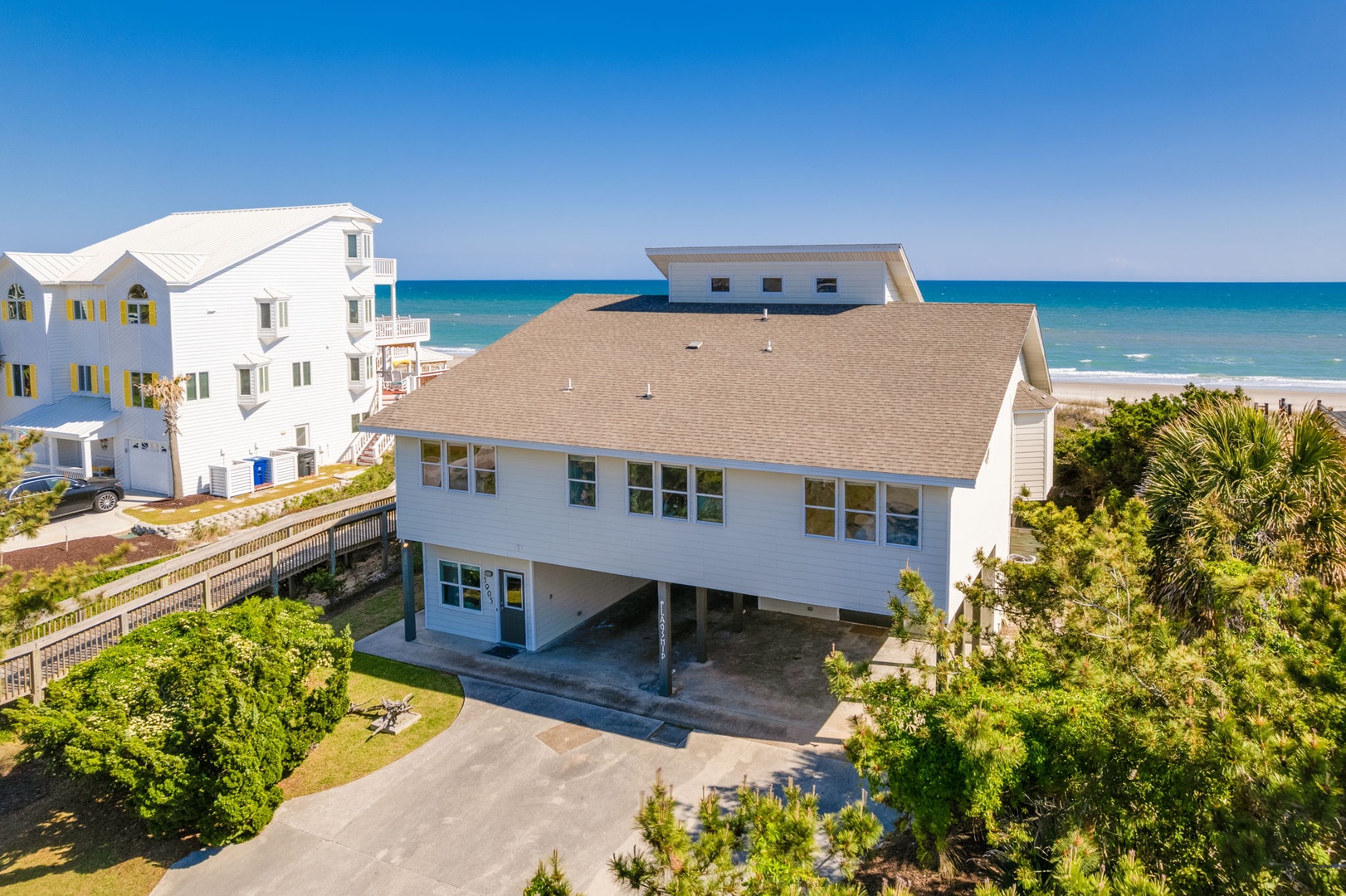 Beachfront property with tropical landscaping and stunning ocean views, just steps from pristine sandy shores.