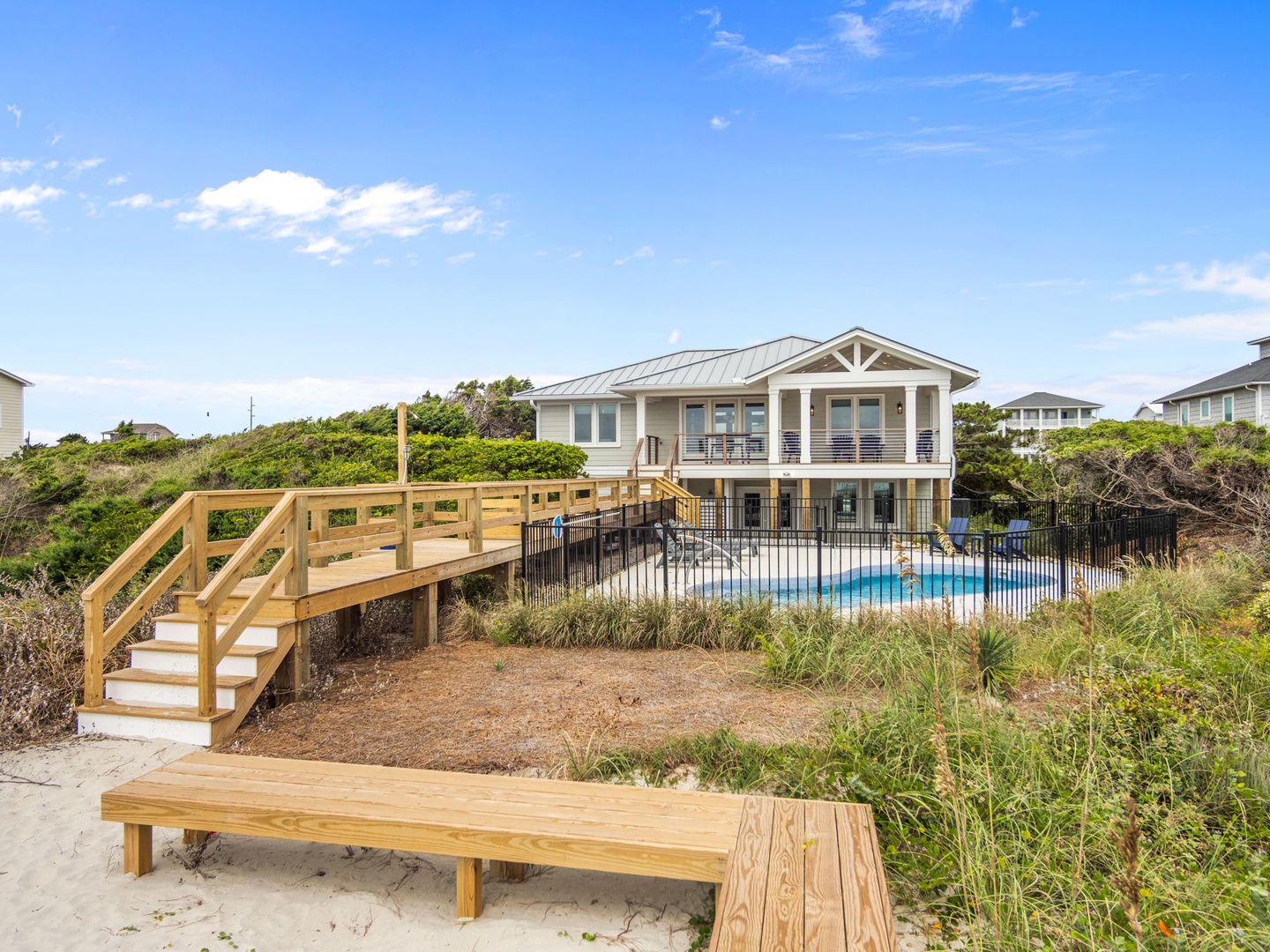 Charming beachfront property with private pool and direct beach access via wooden boardwalk.