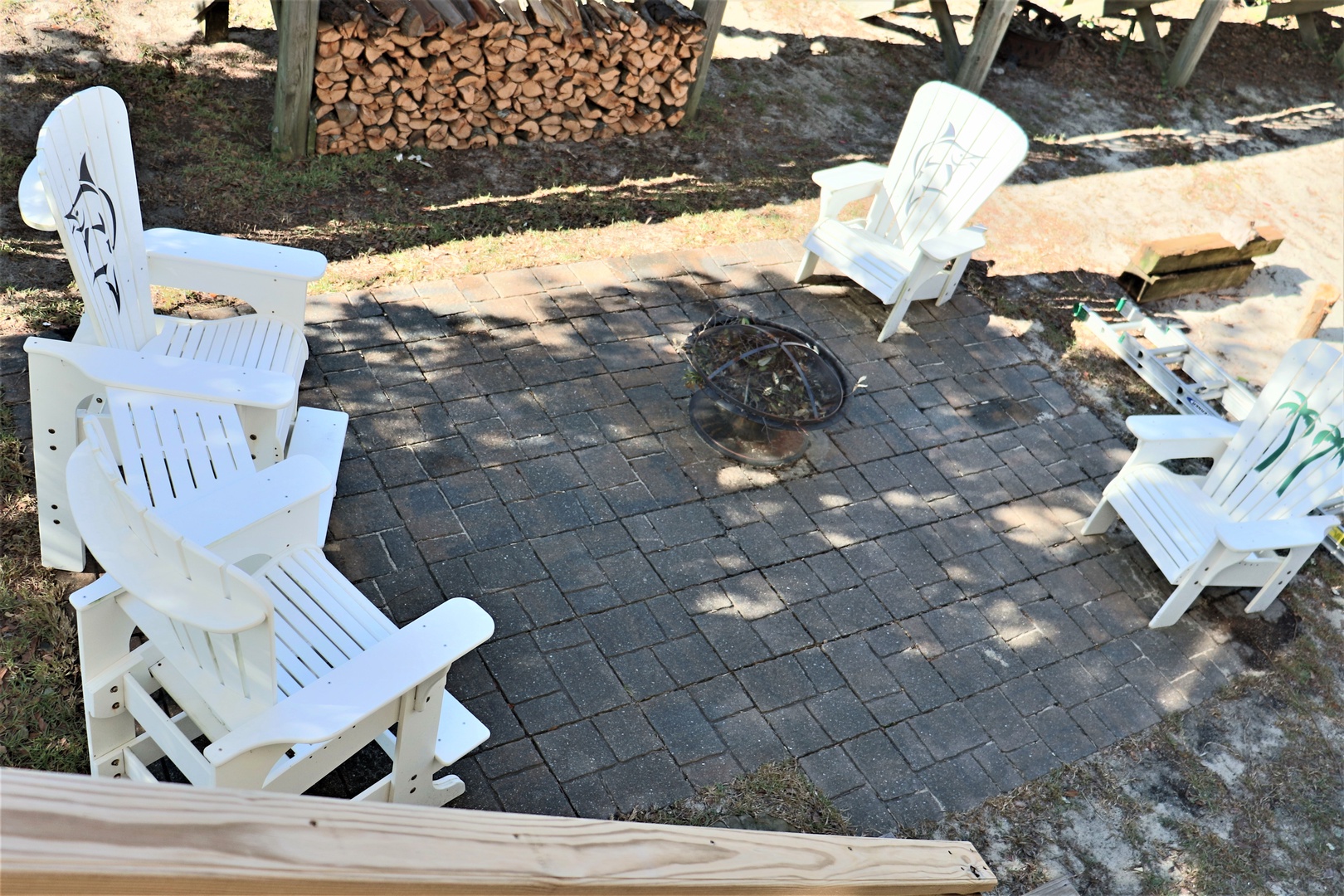 Your private patio features comfortable white chairs arranged around a central fire pit for cozy evenings under the stars.