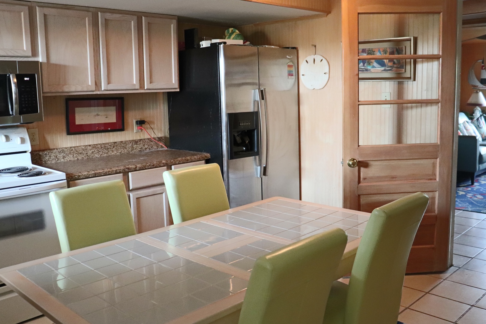 Gather around your spacious kitchen table for memorable meals together, with modern appliances and warm wood cabinetry creating the perfect culinary haven.