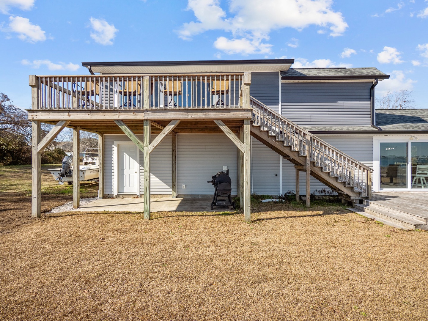 Modern waterfront property featuring elevated deck with water views and covered parking for boats and vehicles.