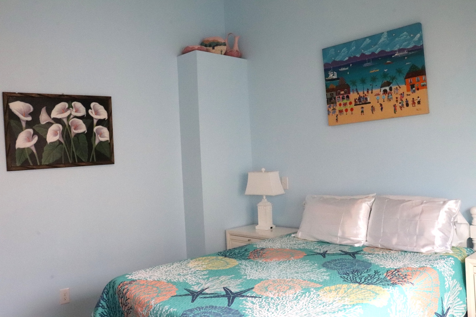 Your cheerful beach-themed bedroom awaits with soft linens, vibrant coastal art, and calming blue walls—perfect for unwinding after sun-soaked days exploring nearby shores.