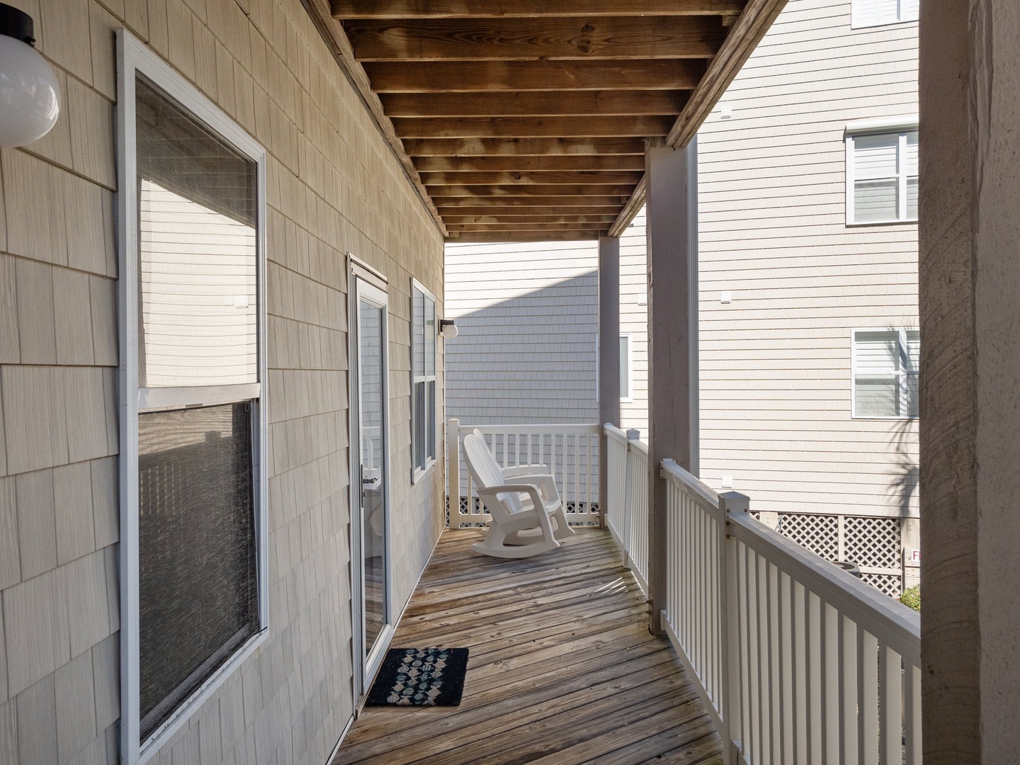 Step onto your private covered balcony where weathered wood beams frame your peaceful retreat. Settle into the rocking chair with morning coffee.