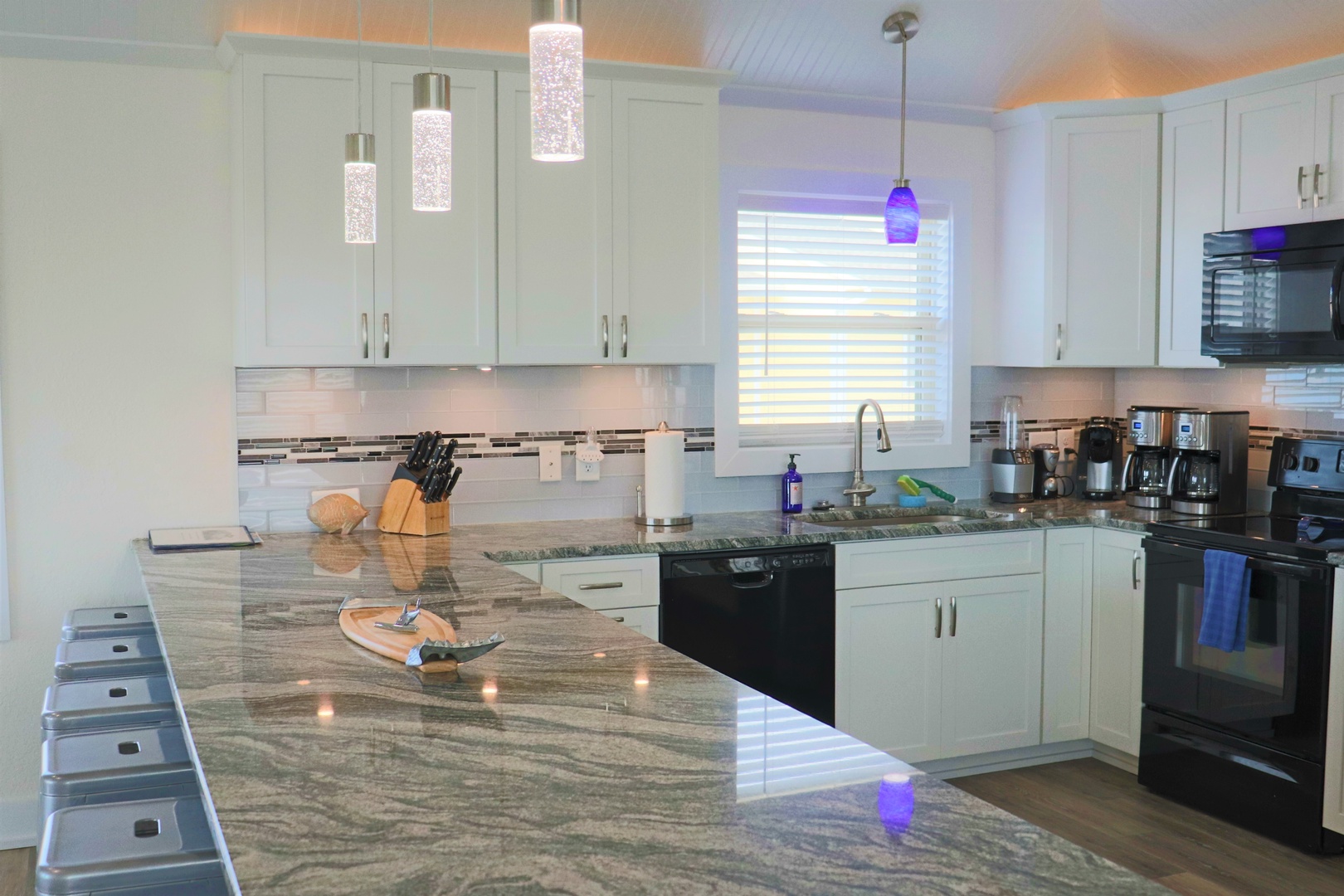 Whip up culinary masterpieces in this stunning granite-countered kitchen, complete with modern appliances and elegant pendant lighting for memorable vacation meals.