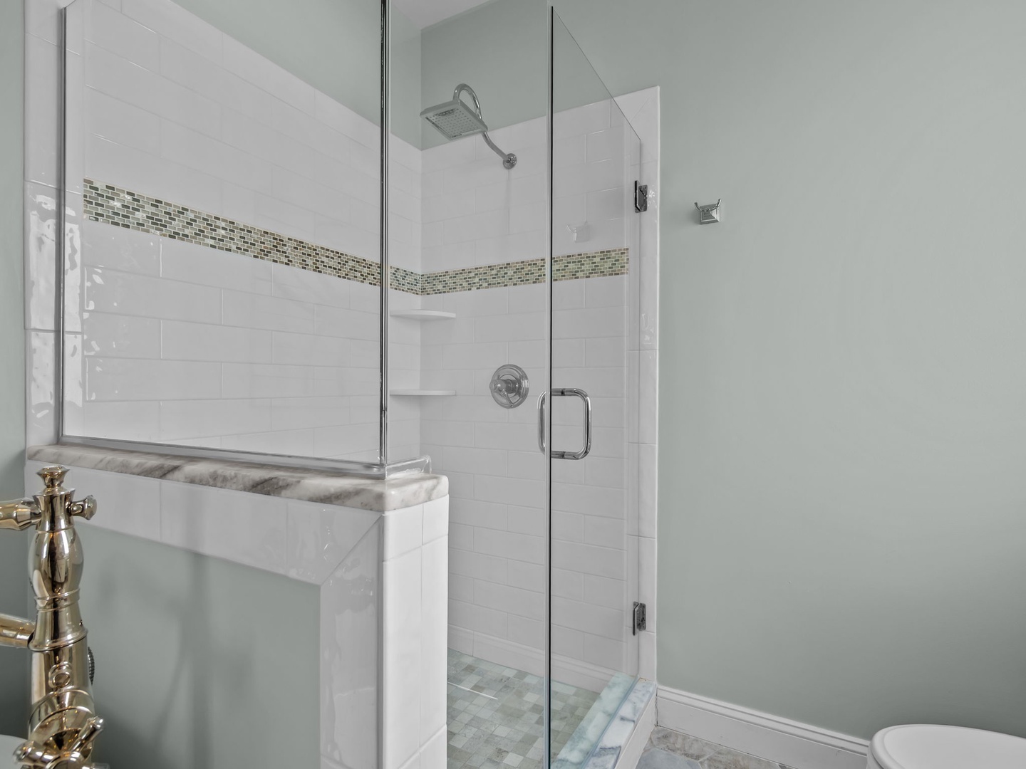 Step into your spa-like bathroom featuring an elegant glass-enclosed shower with gleaming fixtures and sophisticated tile accents.