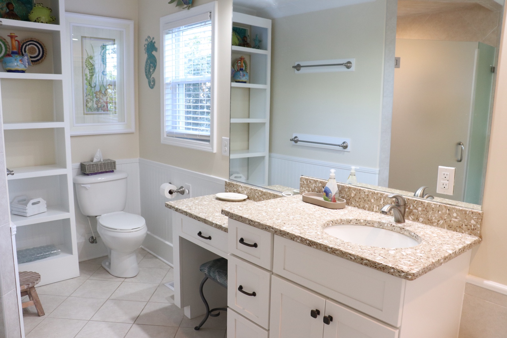 Pamper yourself in this spacious bathroom with granite countertops, ample storage, and coastal-inspired decor for your relaxing getaway.