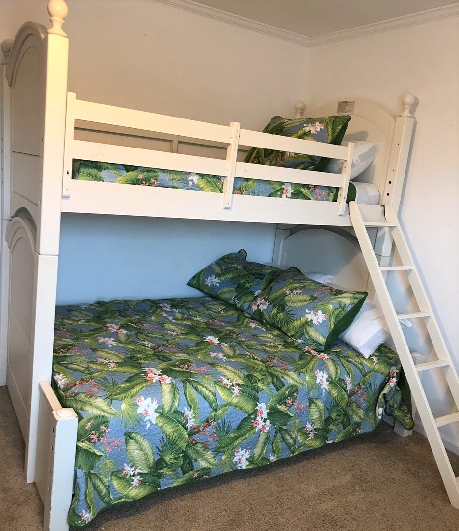 Rest easy in your tropical-themed bunk beds, where vibrant palm leaf bedding creates a fun island escape for family adventures.