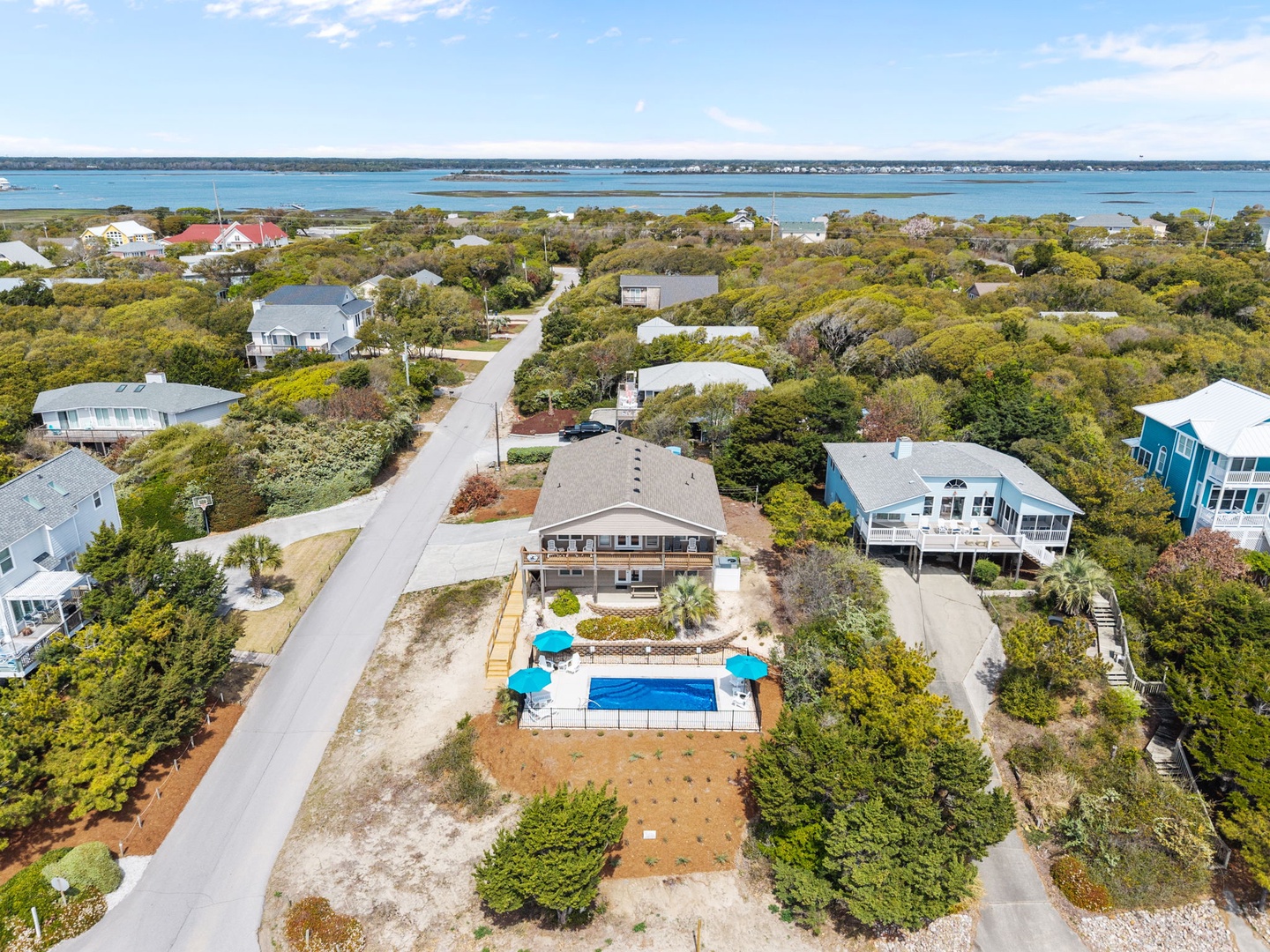 Coastal retreat featuring a sparkling pool surrounded by natural beauty and water views in this peaceful neighborhood.