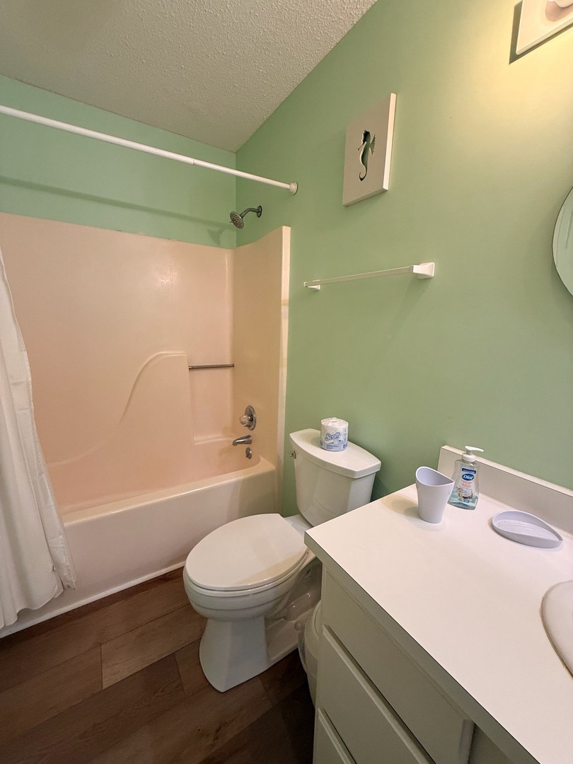 Your private bathroom features a fresh coastal palette with a full tub-shower combo, vanity, and thoughtful touches to help you feel right at home.