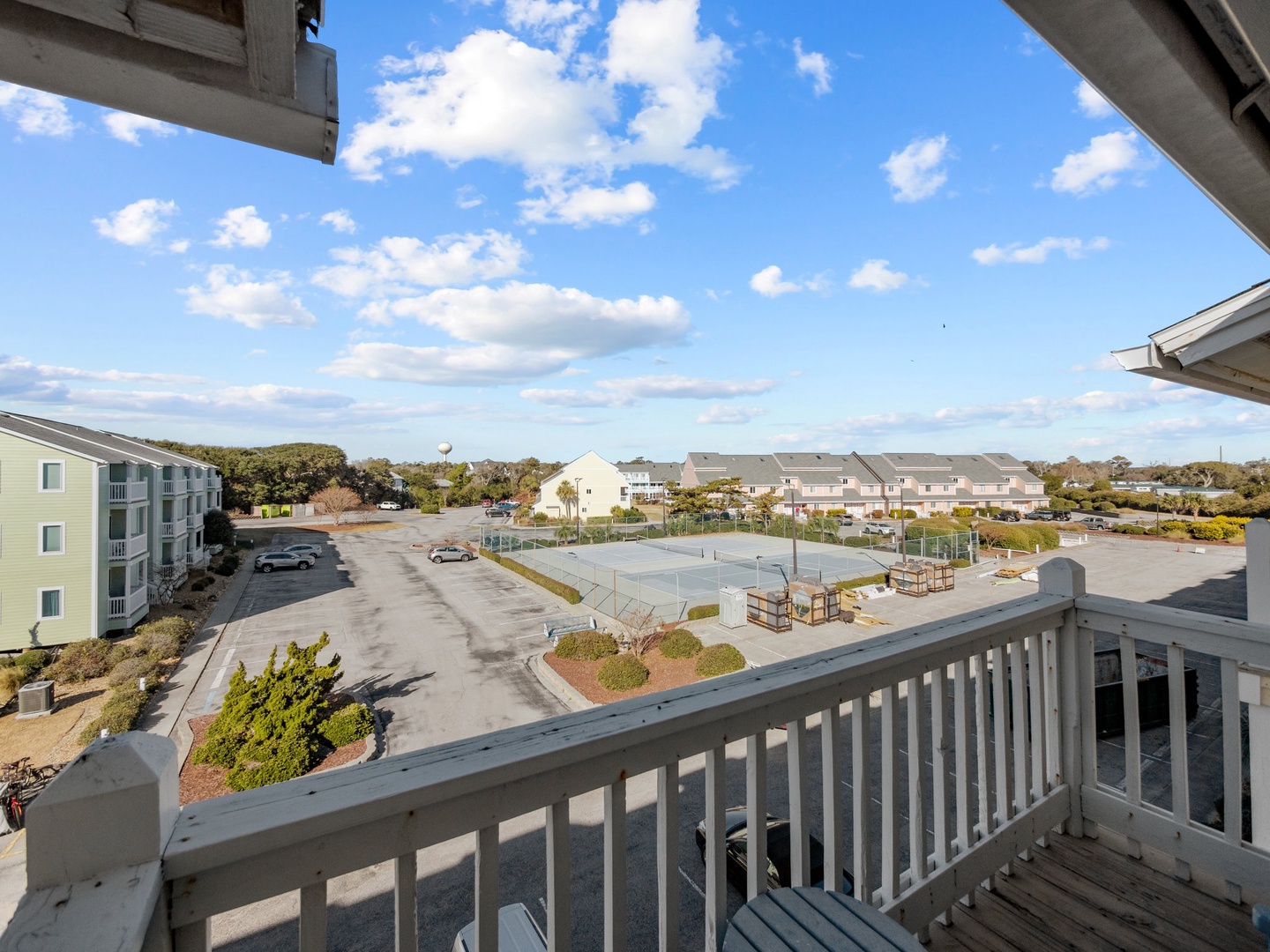 Spacious balcony offers views of tennis courts and community amenities below.