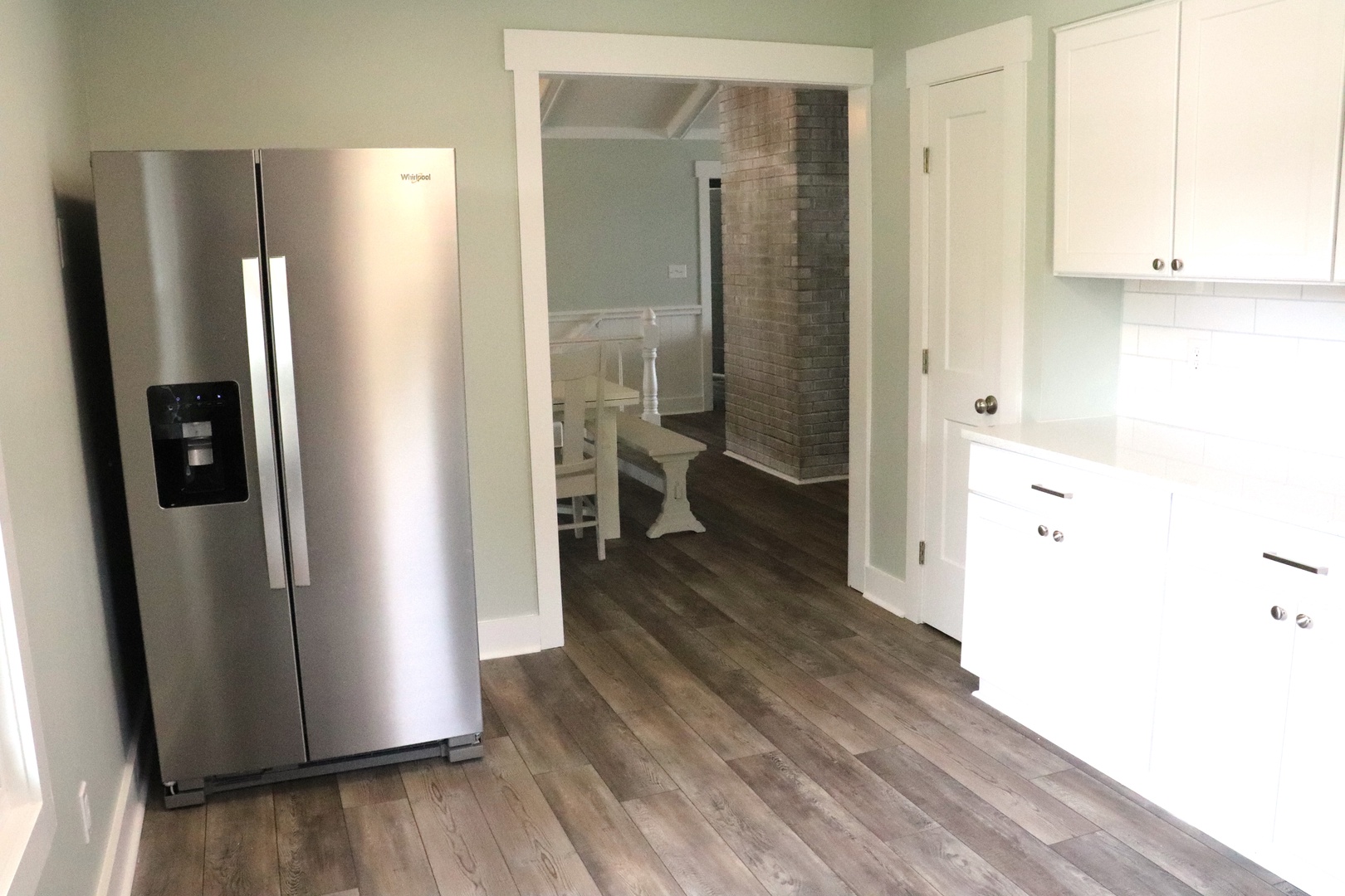 Your fully equipped kitchen features stainless steel appliances and crisp white cabinetry, with beautiful hardwood floors flowing throughout your space.