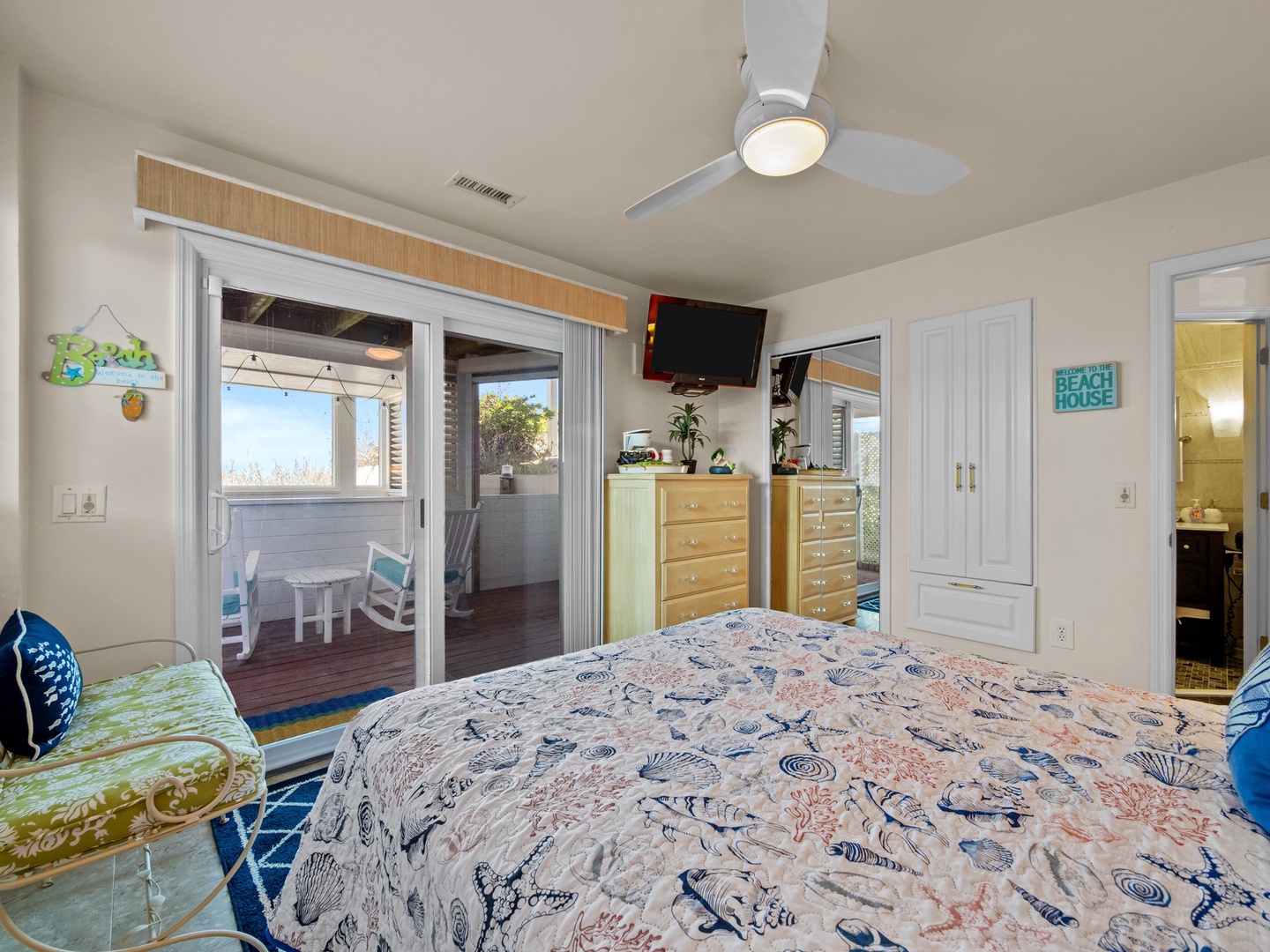Wake up to ocean views through sliding doors that open to your private balcony. Coastal charm meets comfort with beach-themed decor.
