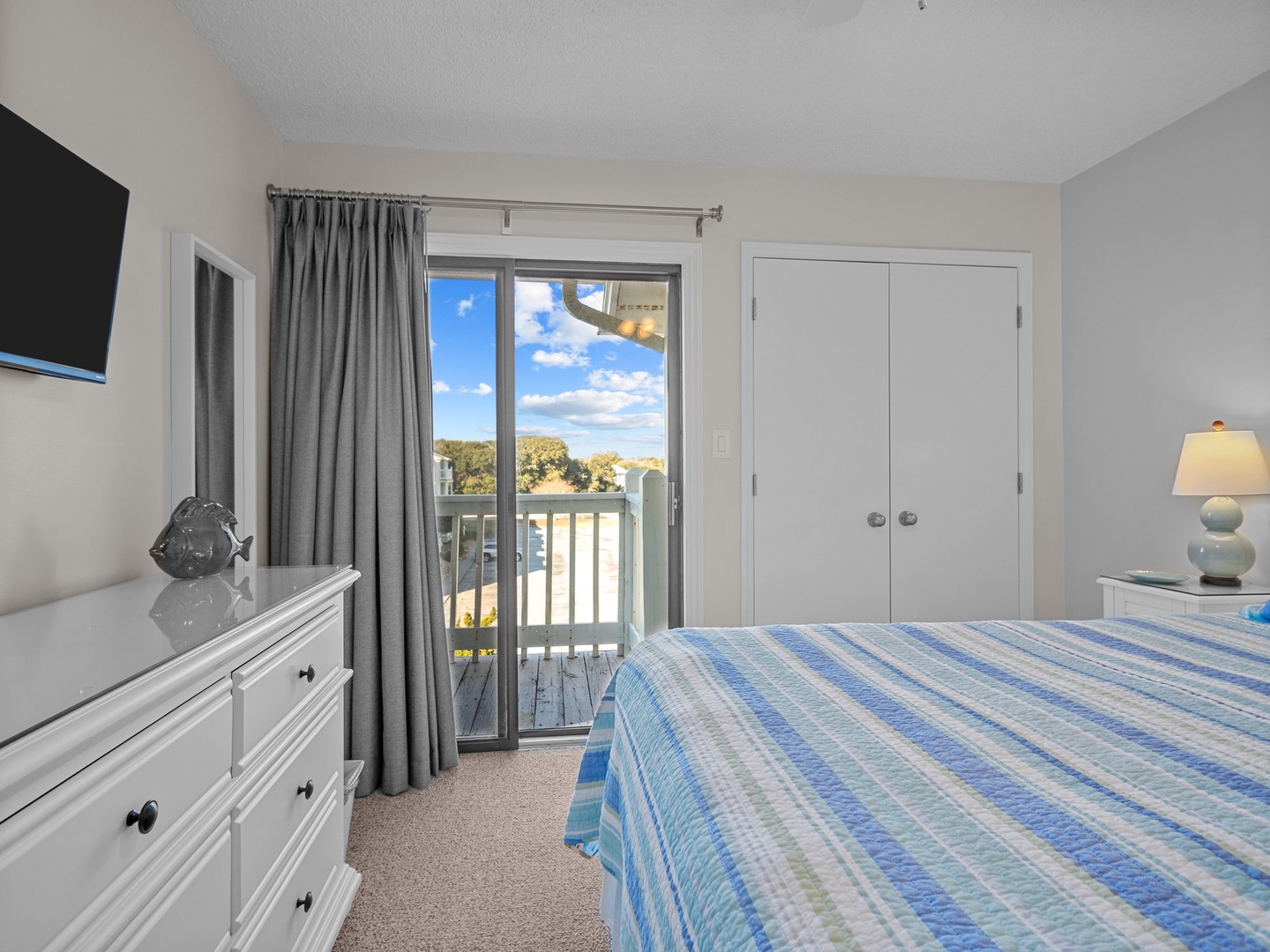 Wake up to stunning views from your comfortable bedroom, featuring a private balcony overlooking lush landscapes and distant waters.