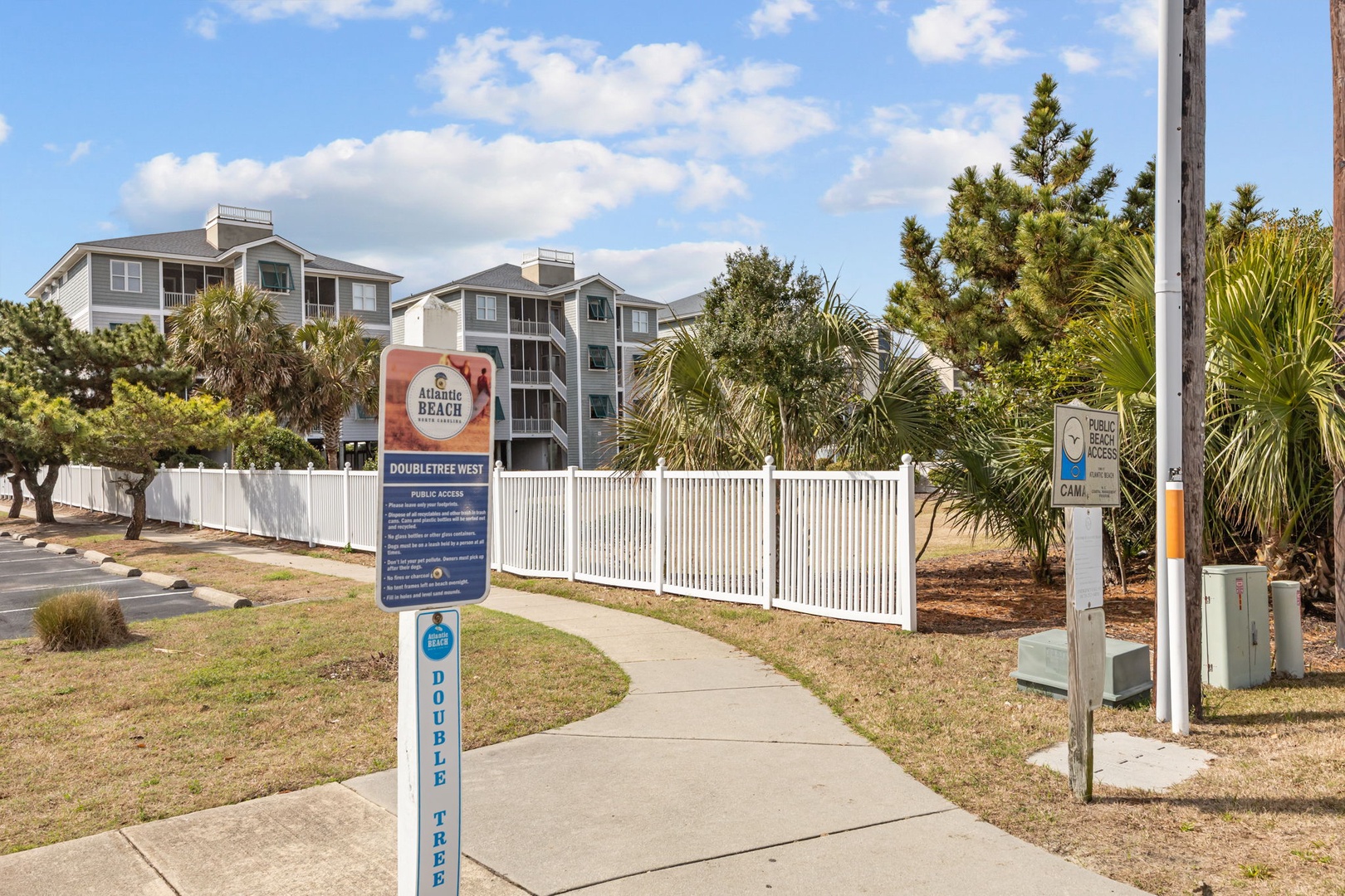 Atlantic Beach Resort entrance with clear signage and walkway leading to the multi-story property buildings surrounded by tropical landscaping.