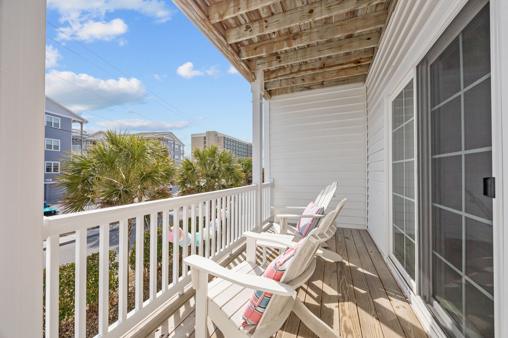 Relax in comfortable Adirondack chairs on your private balcony, where palm trees and coastal views create the perfect backdrop for morning coffee.