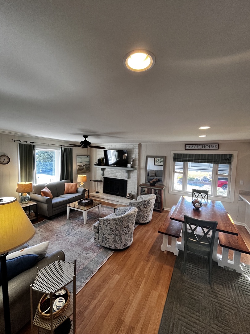 Relax in this spacious living room with cozy seating, modern TV setup, and warm wood floors.