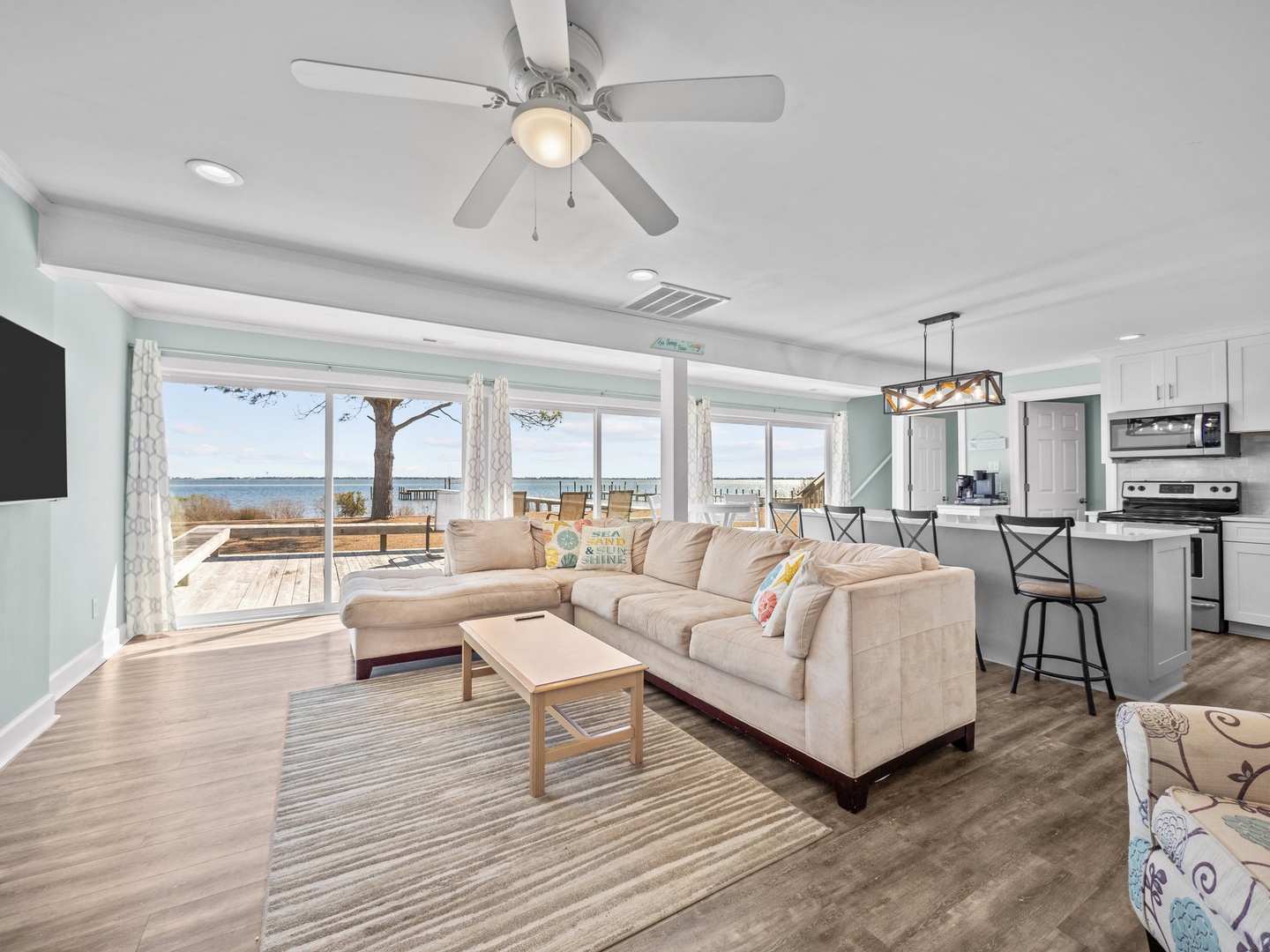 Unwind in your waterfront haven where plush seating meets stunning lake views through floor-to-ceiling windows, creating the perfect coastal retreat.