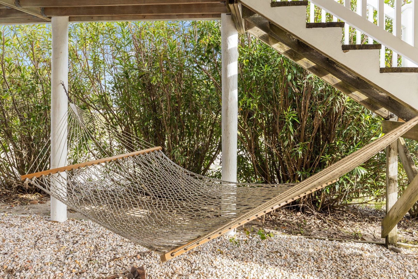 Sway gently in your private hammock beneath the deck, surrounded by lush tropical greenery for the perfect afternoon escape.