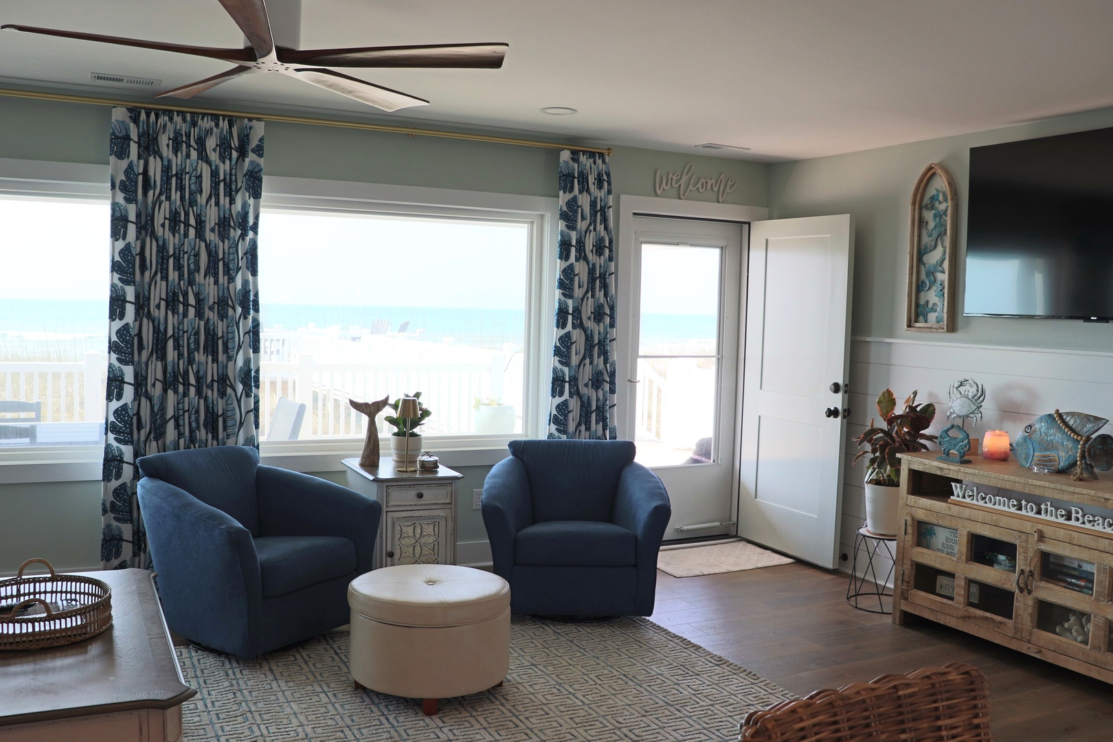 Unwind in your coastal living room with plush blue chairs, calming ocean views, and thoughtful touches that welcome you to paradise.