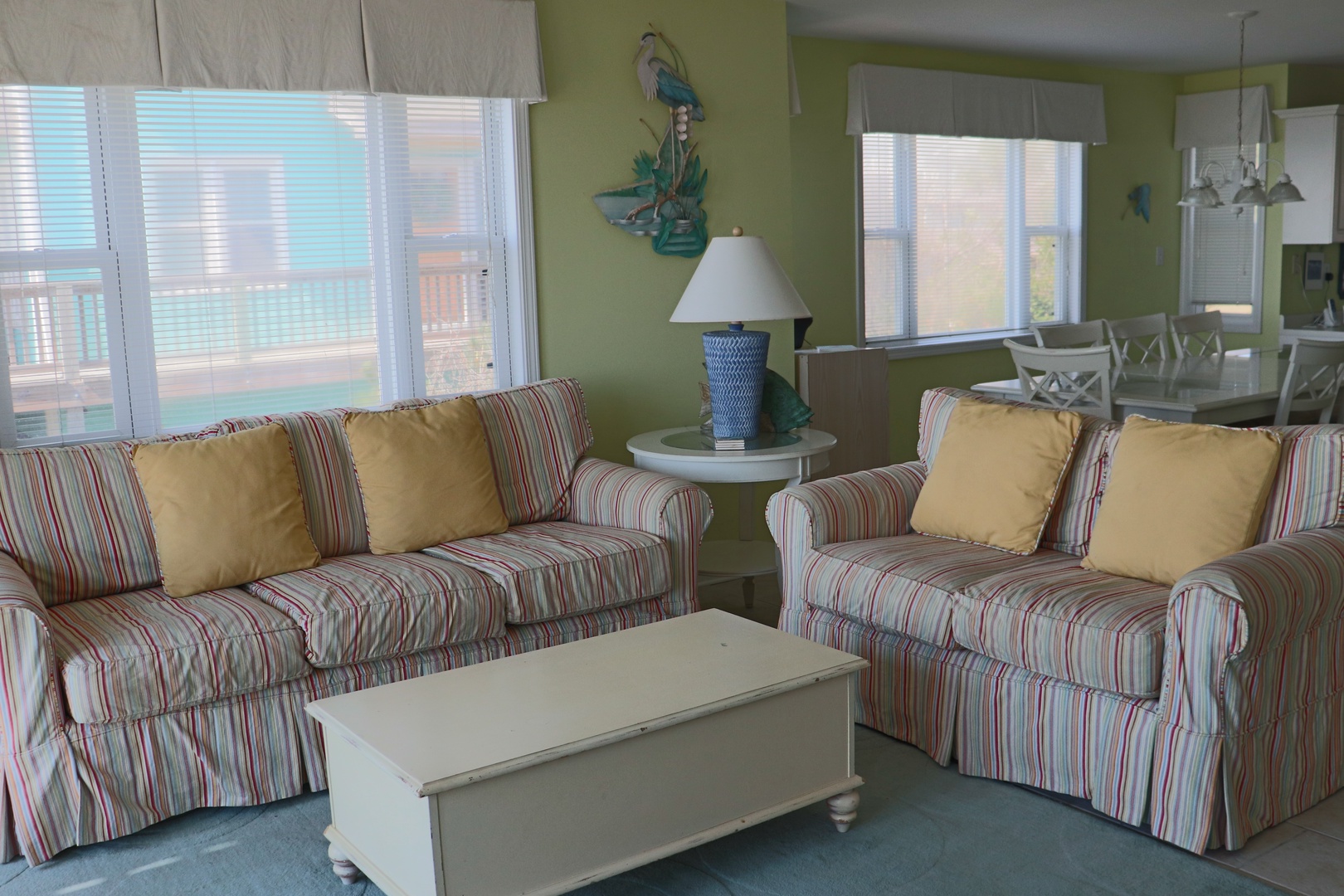 Unwind in your bright, coastal living space with striped sofas and cheerful decor that perfectly captures beachside comfort.