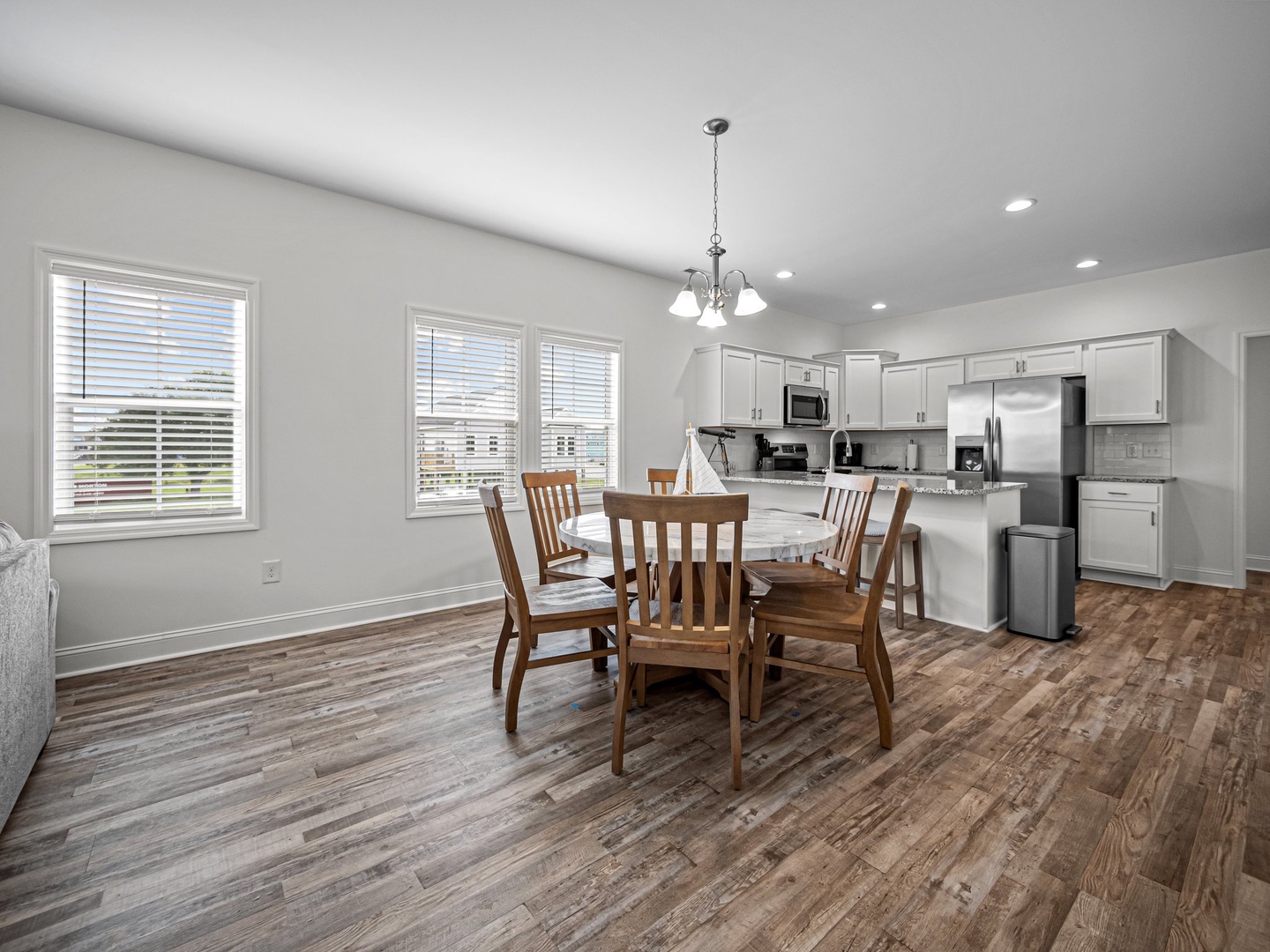 Your spacious open-concept living combines a modern kitchen with stainless appliances and a welcoming dining area with warm wood floors throughout.
