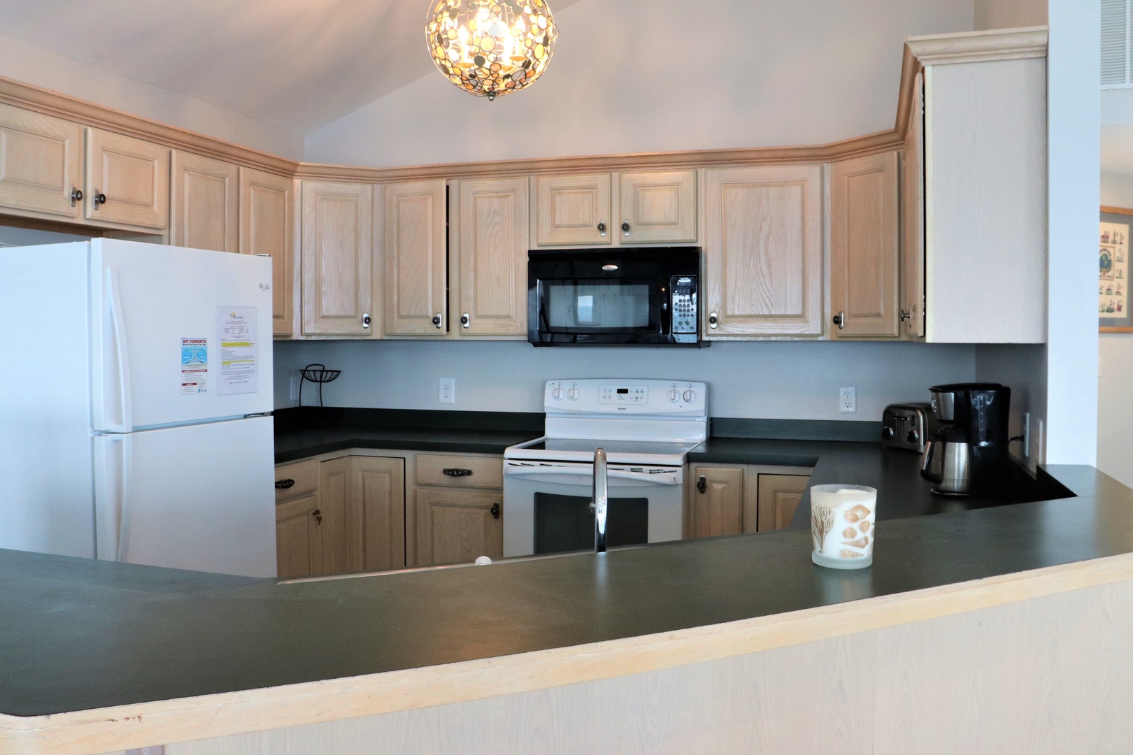 Your fully-equipped kitchen invites home-cooked meals with spacious counters, modern appliances, and warm wood cabinetry.