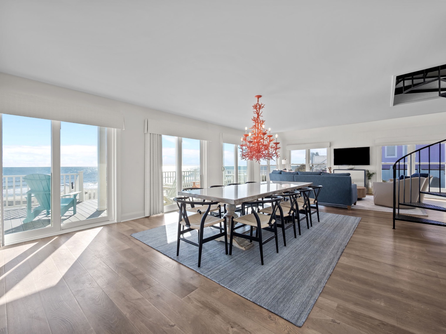 Step into your stylish oceanfront dining space with stunning coral chandelier and panoramic sea views through floor-to-ceiling windows.