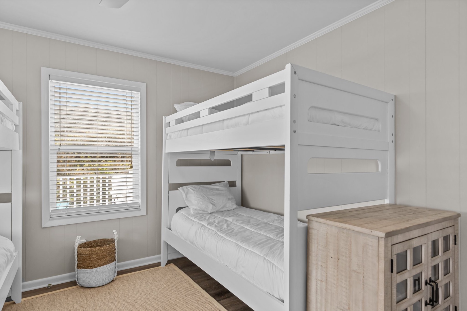 Your kids will love these cozy white bunk beds, perfectly placed by the sunny window for afternoon reading adventures.