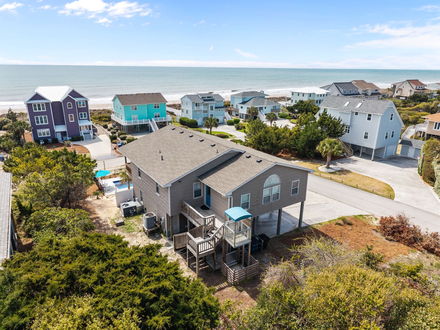 Coastal vacation home sits perfectly positioned between beach and neighborhood, offering easy access to sandy shores and peaceful residential charm.