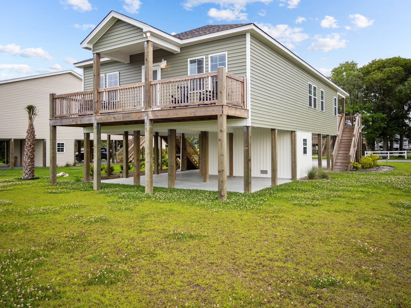 A charming raised beach house with covered parking and deck, nestled in a peaceful coastal neighborhood with mature trees.