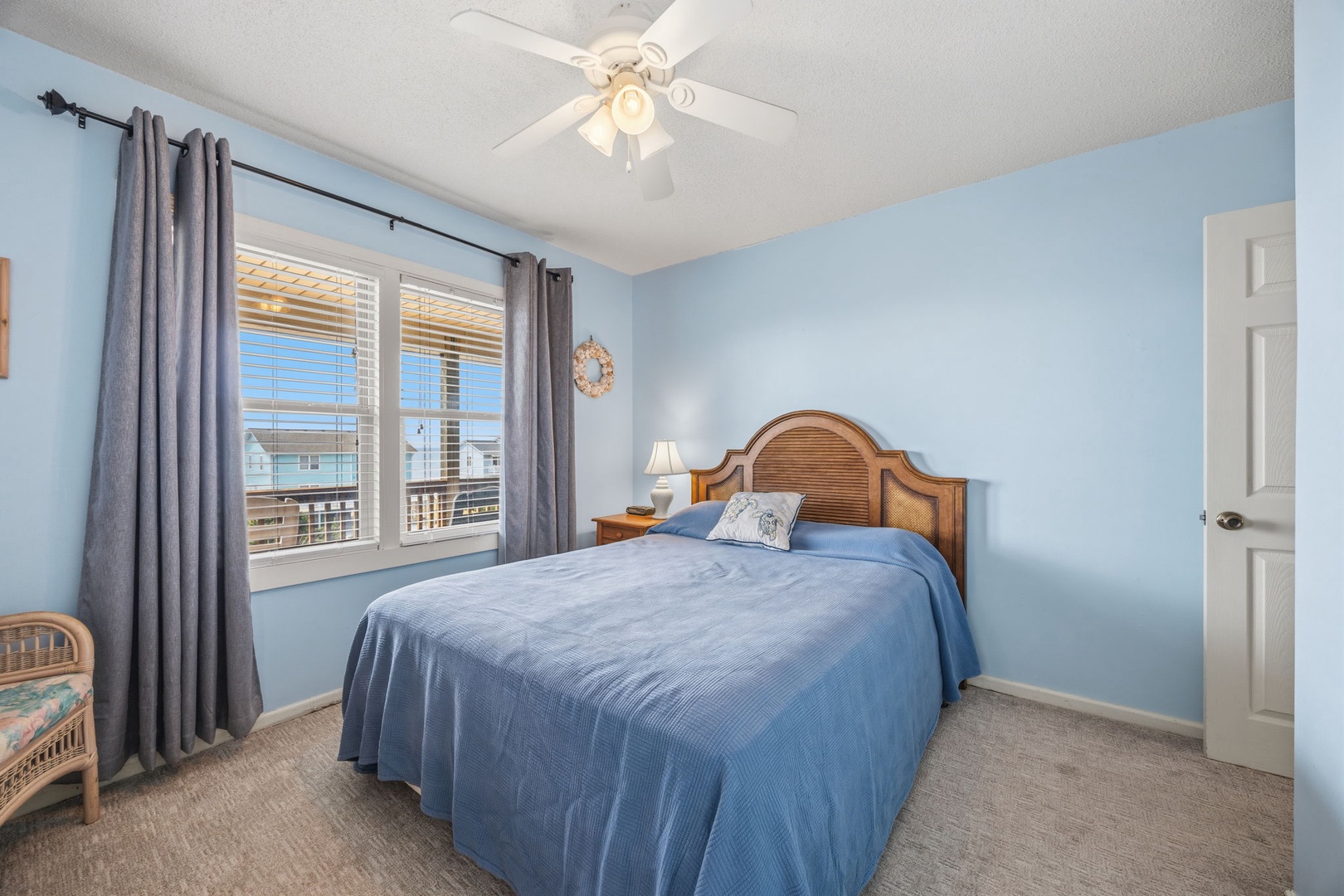 Drift off to sleep in this tranquil blue bedroom where gentle coastal breezes flow through your windows and soft linens await your arrival.