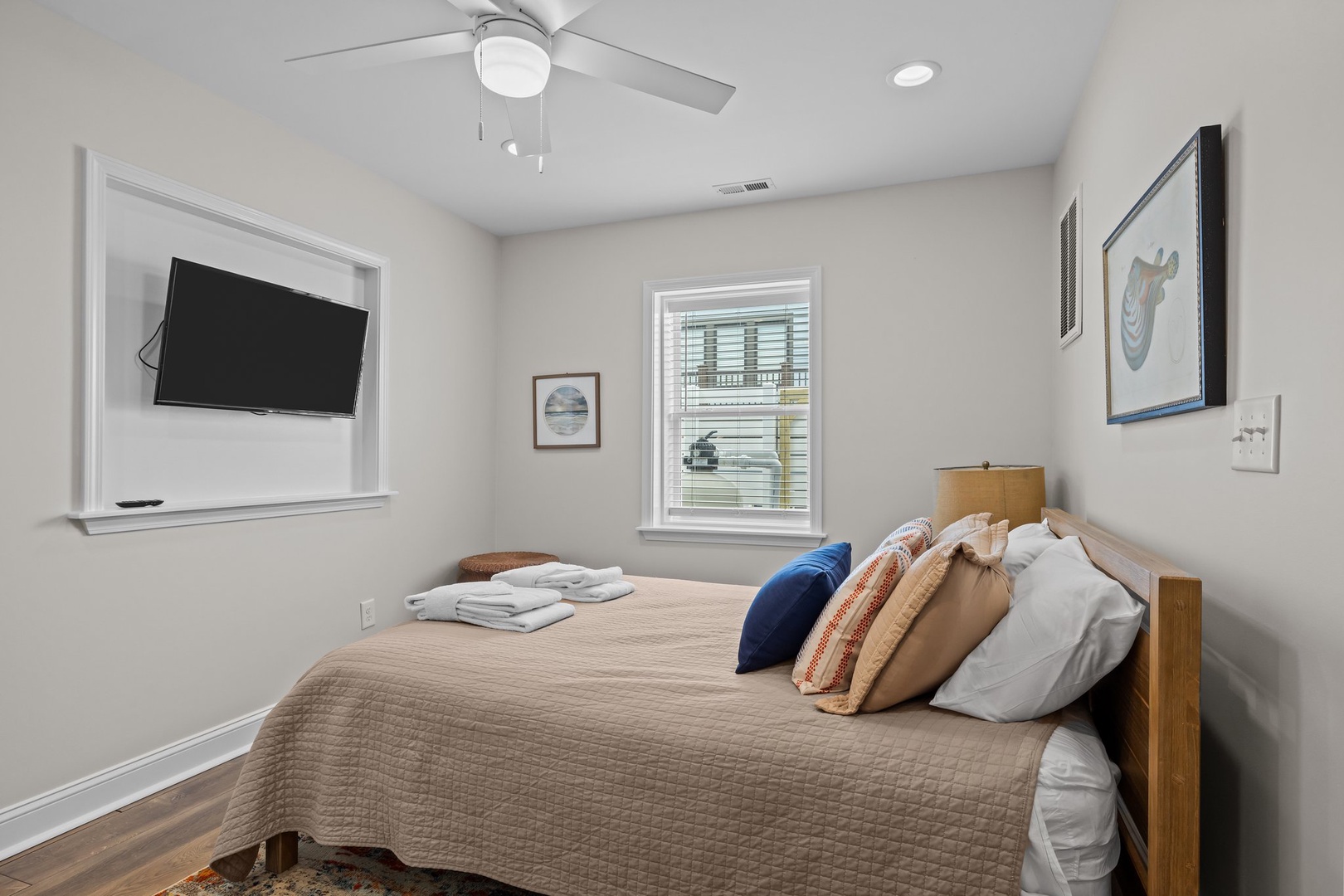 Drift off to sleep in your cozy bedroom, complete with ceiling fan and wall-mounted TV for ultimate comfort and convenience.