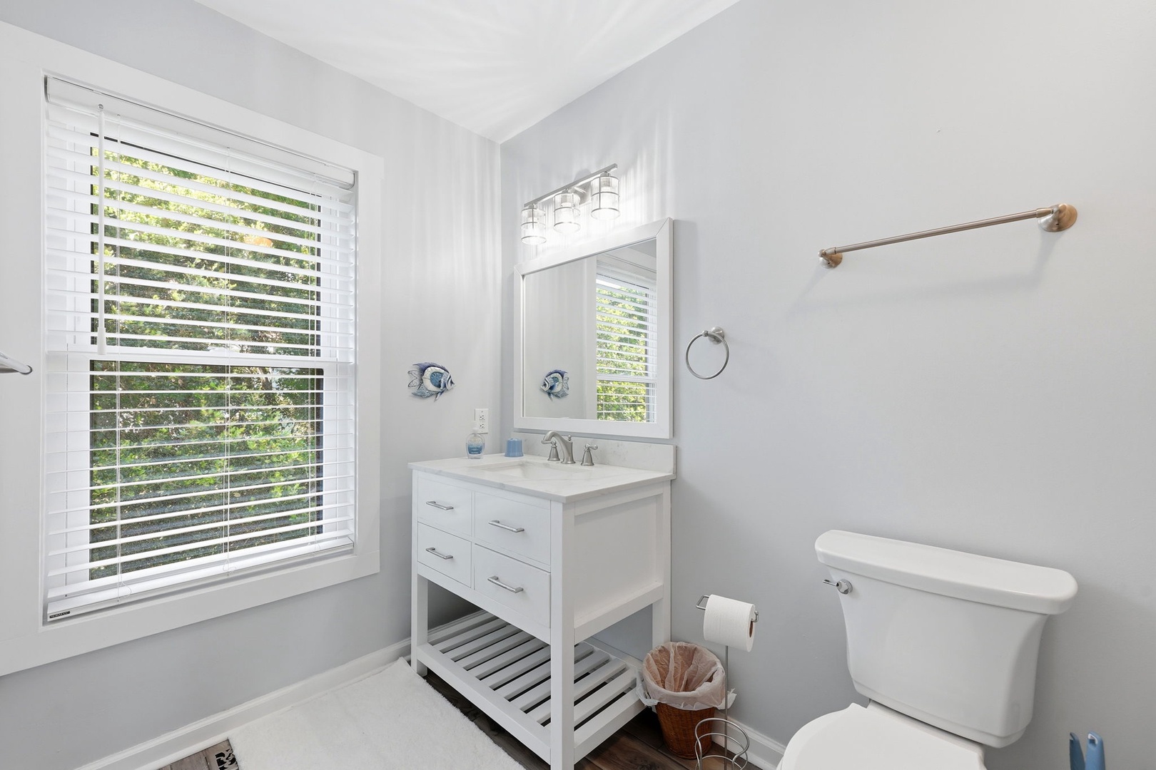 Your light-filled bathroom features soft coastal tones, crisp white accents, and plenty of natural light streaming through dual windows. The open vanity adds a breezy, spa-like touch perfect for refreshing mornings.
