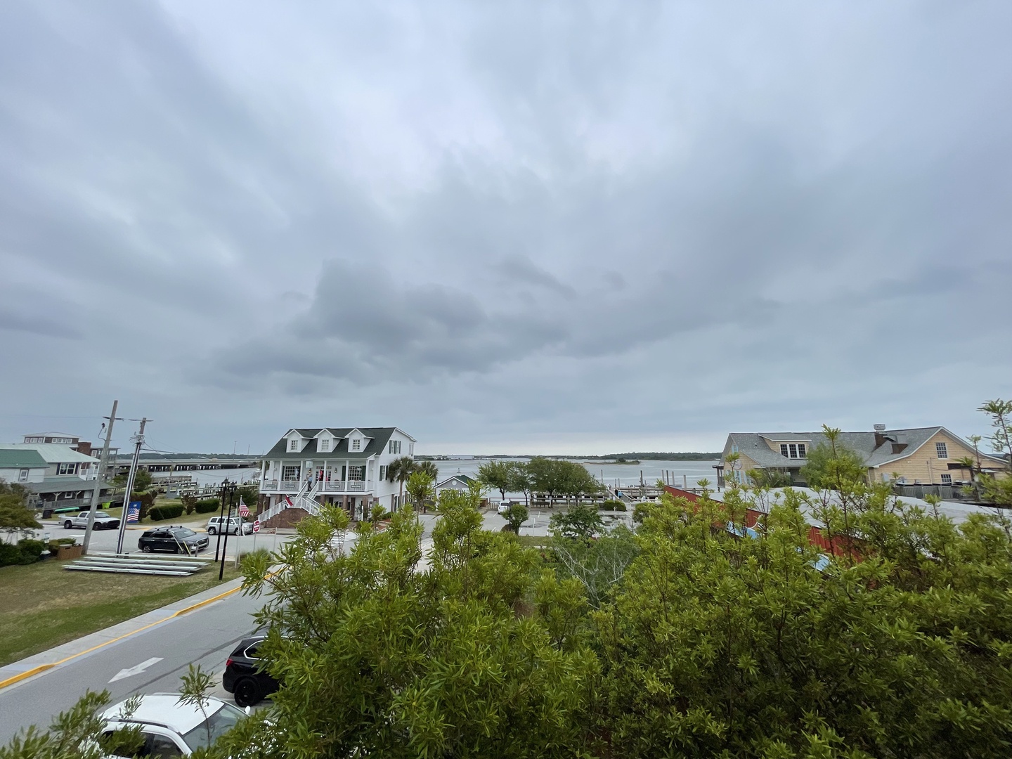 Charming waterfront community with coastal homes dotting the scenic shoreline under dramatic cloudy skies.
