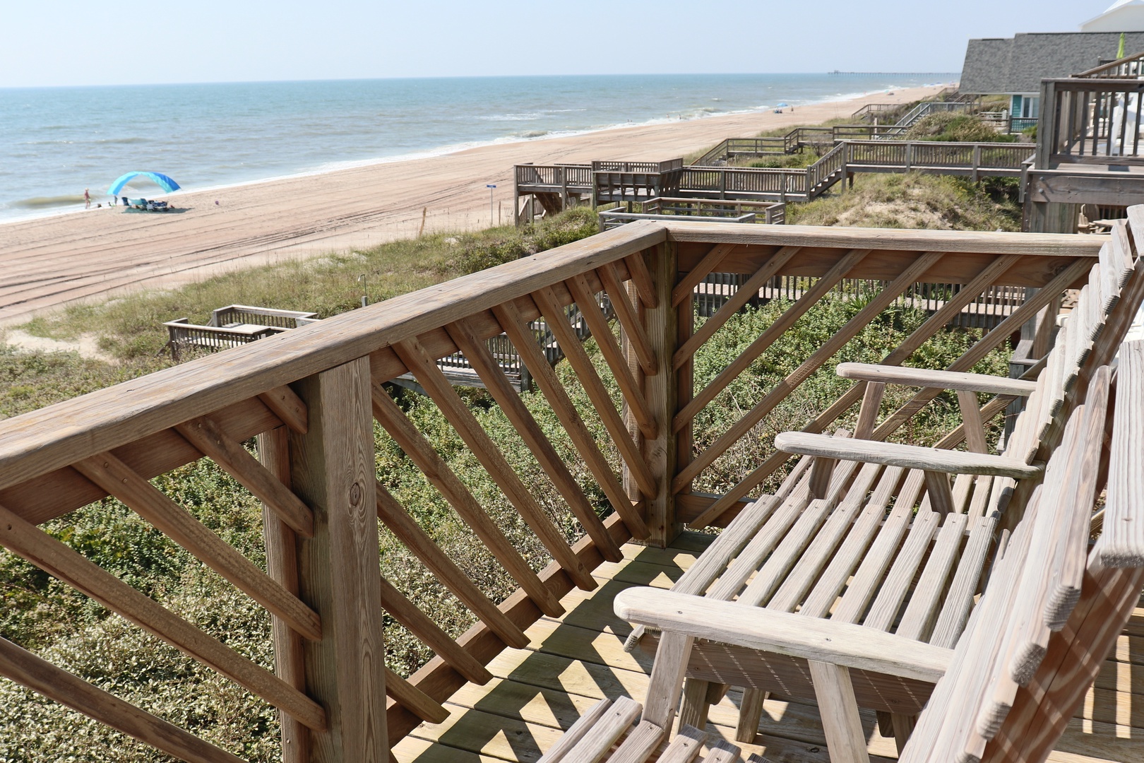 Wooden beach access stairs lead to pristine sandy shores where ocean waves await your seaside escape.