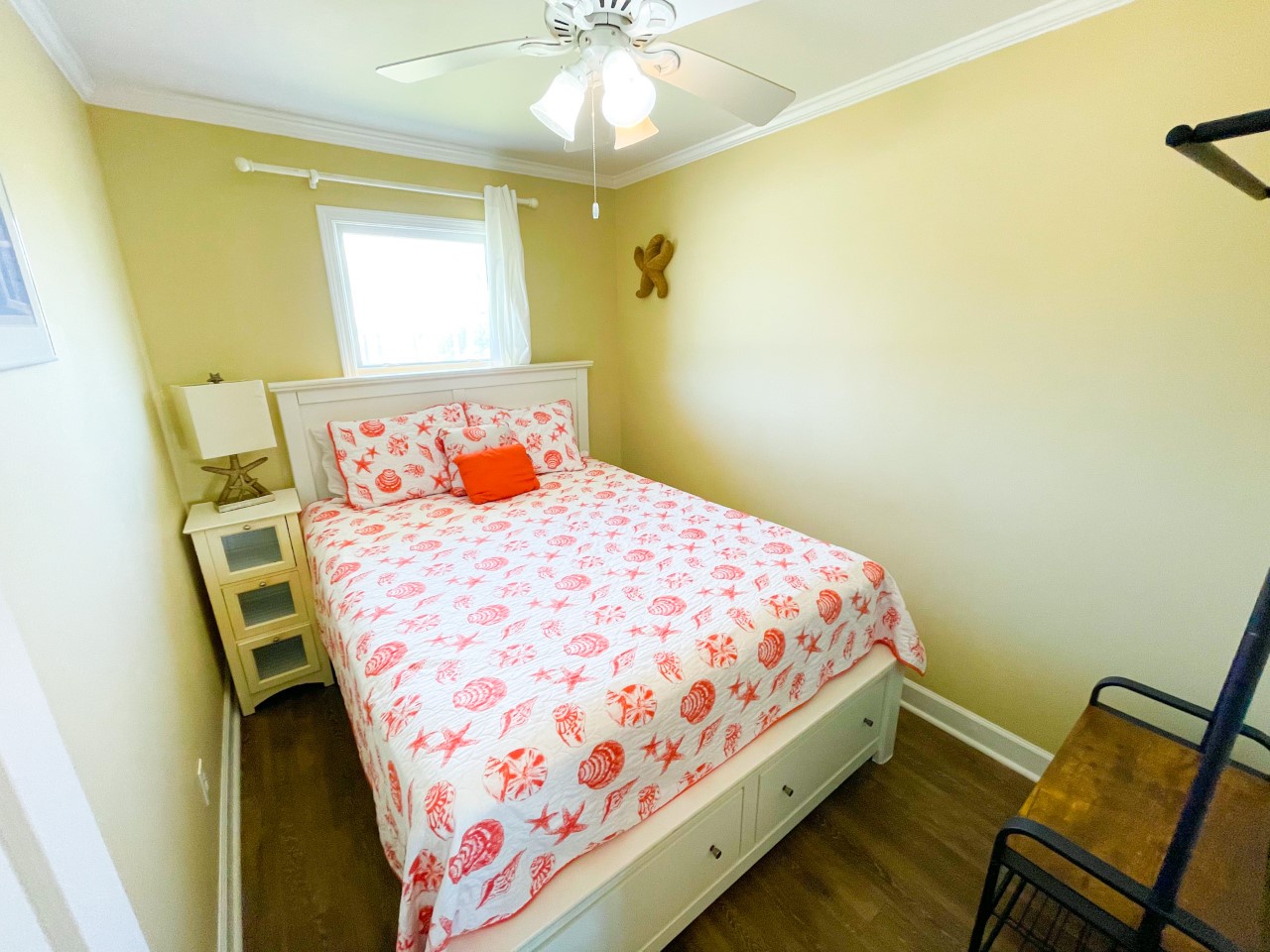 Drift off in your cheerful coastal bedroom, where soft yellow walls and coral bedding create a warm seaside retreat.