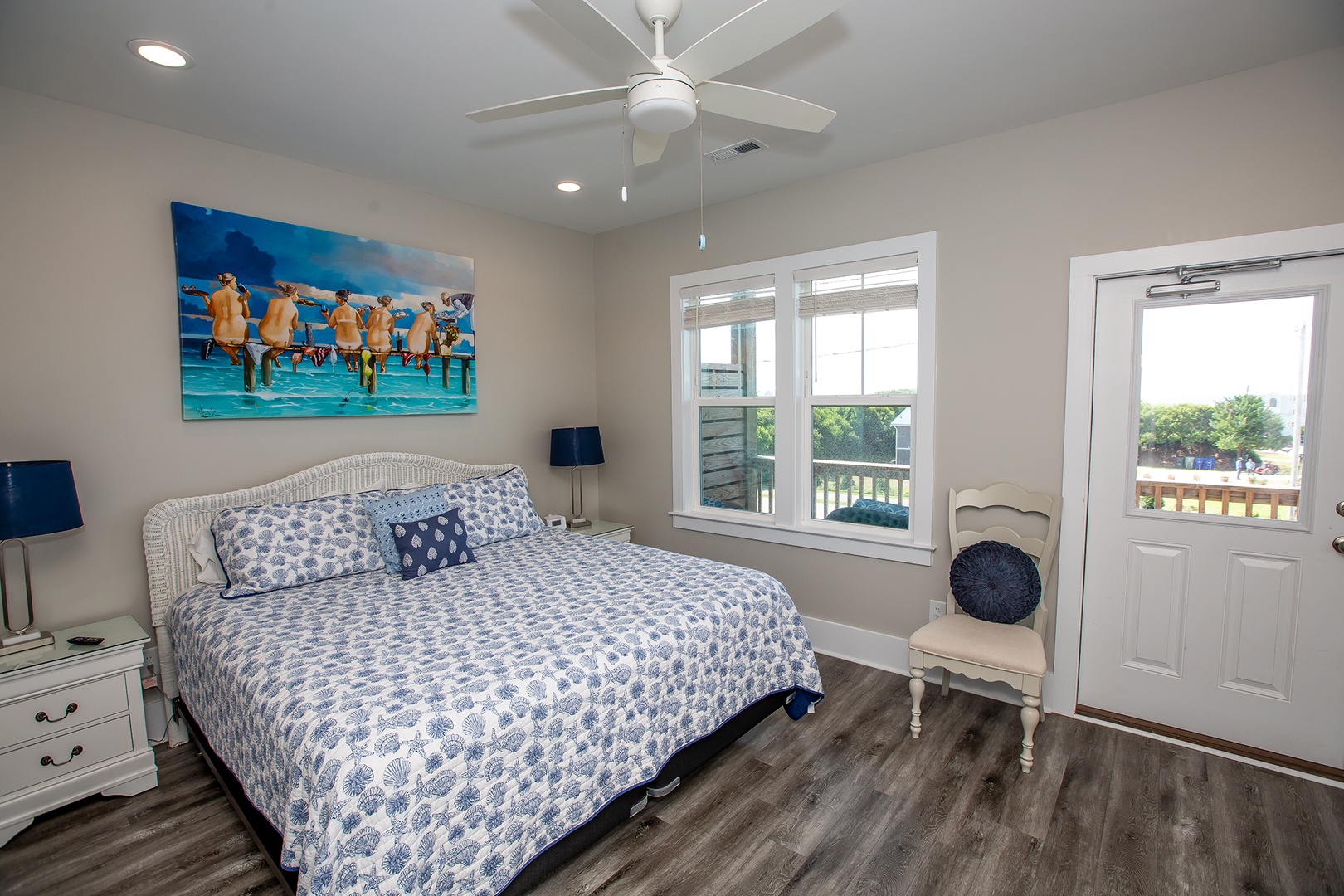 Your coastal bedroom awaits with crisp blue linens, cheerful artwork, and French doors opening to your private balcony.