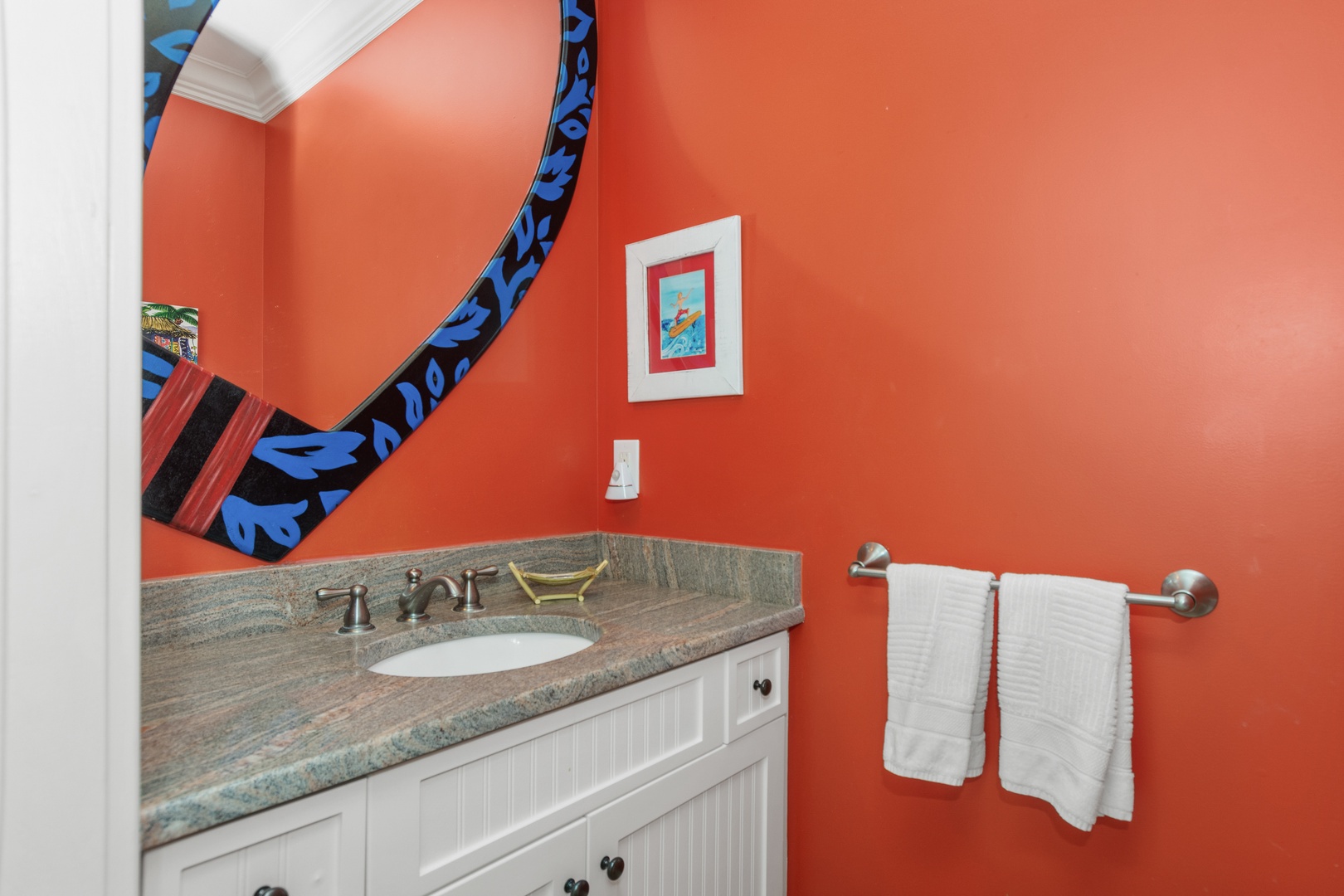 Step into your vibrant powder room where coral walls warm the space and colorful accents add playful charm to your daily routine.