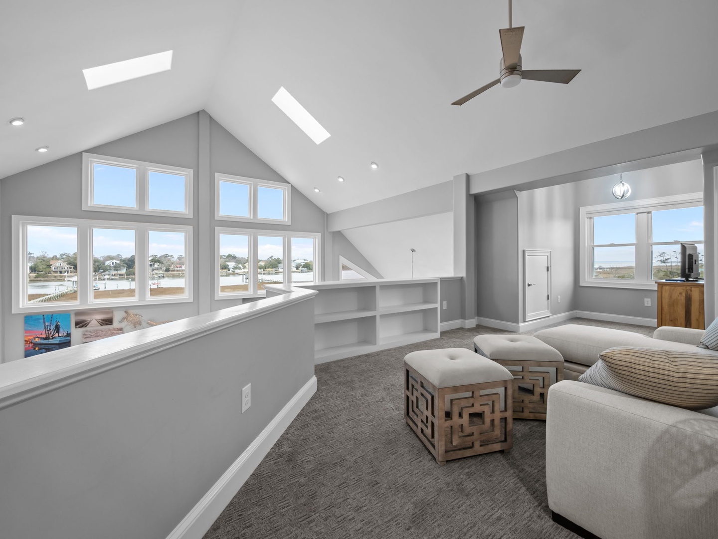 Relax in your bright loft space with vaulted ceilings, skylights, and panoramic windows showcasing beautiful water views.
