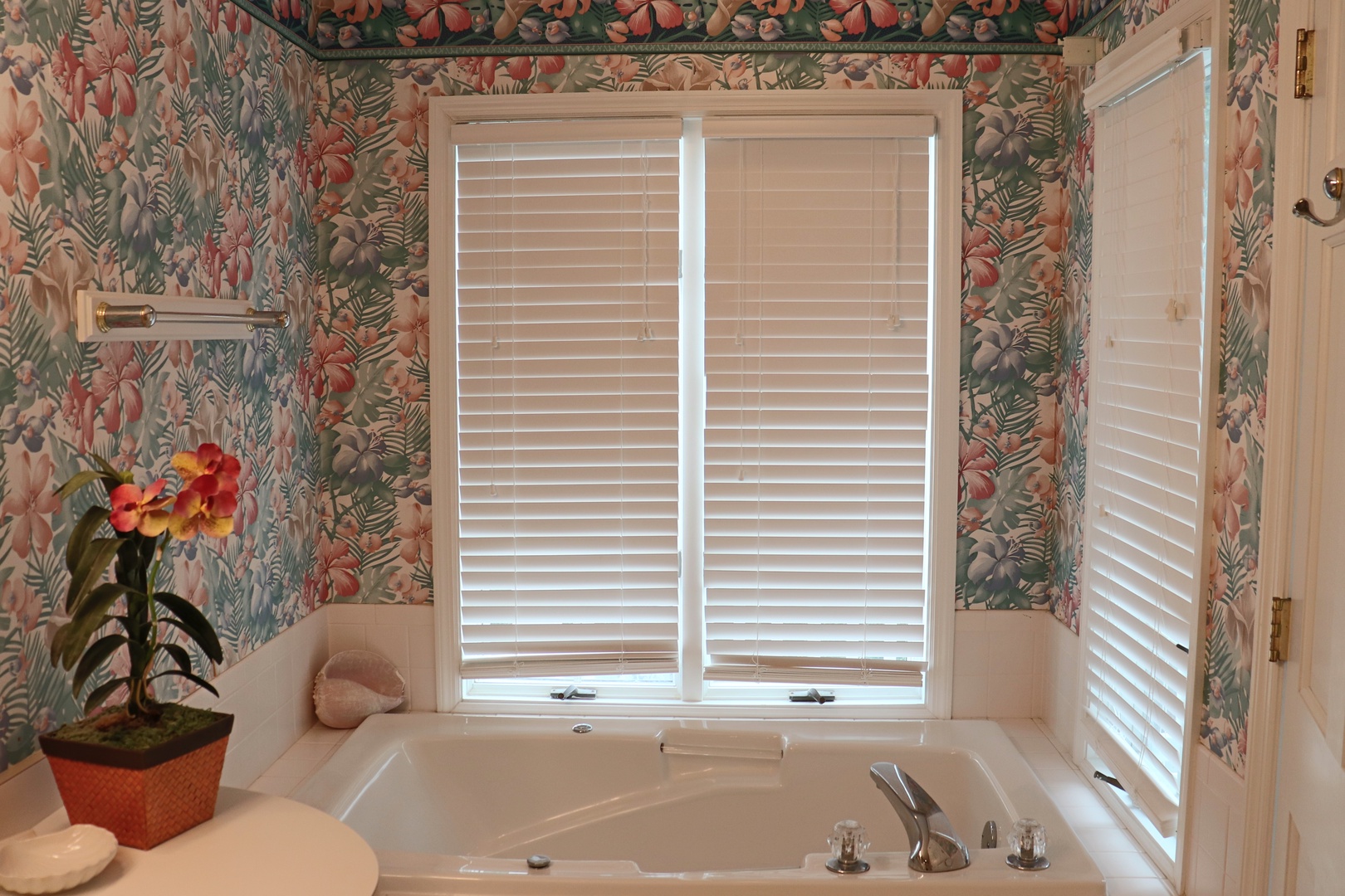 Sink into your private jetted tub surrounded by tropical wallpaper and natural light filtering through plantation shutters.