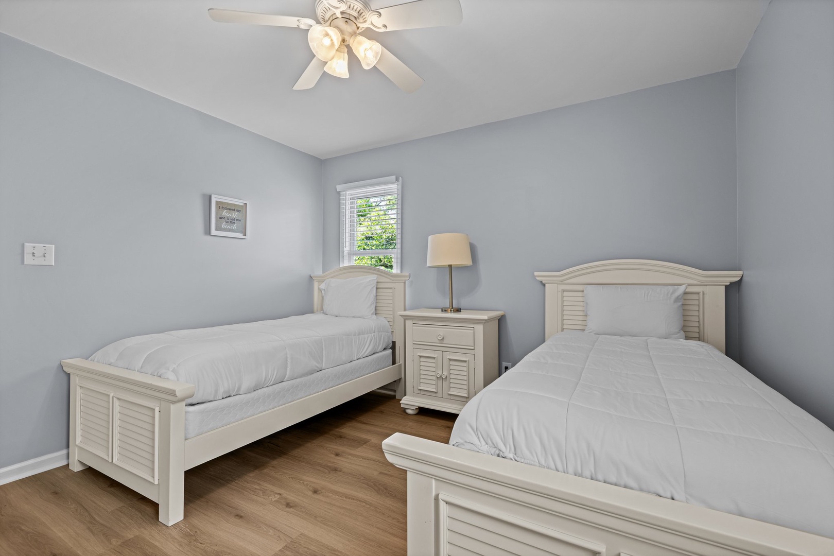 Rest peacefully in your serene twin bedroom, where soft gray walls and matching white furniture create a calming retreat for restful nights.