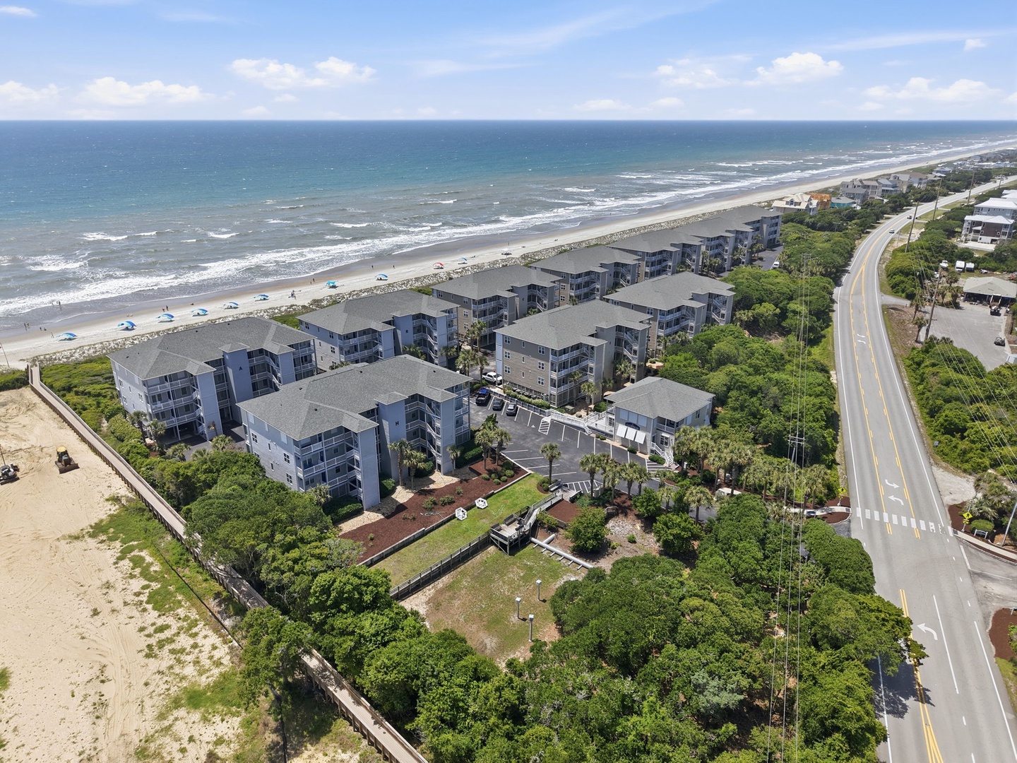 Beachfront property complex situated directly along a pristine stretch of sandy coastline, offering close proximity to the ocean and easy beach access for guests.