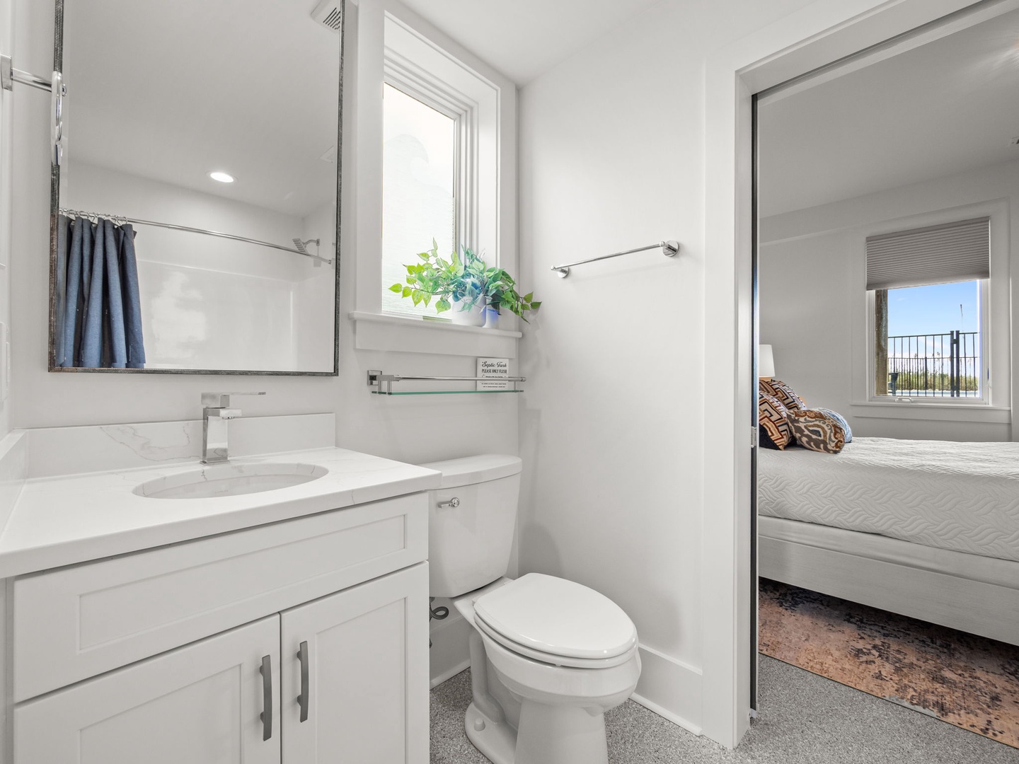 Your modern guest bathroom features sleek white finishes and thoughtful touches, with the bedroom just steps away for your convenience.