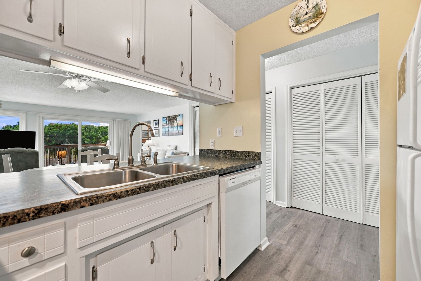 A bright, modern kitchen awaits you with granite counters, stainless steel sink, and a view of lush greenery through the window—your home base for morning coffee and meal prep.
