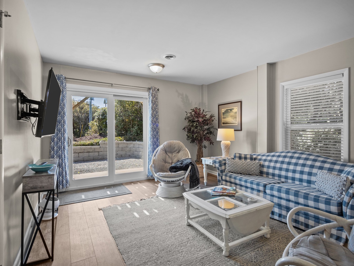 Sink into soft blue gingham seating as morning light streams through your patio doors, creating the perfect spot to unwind.