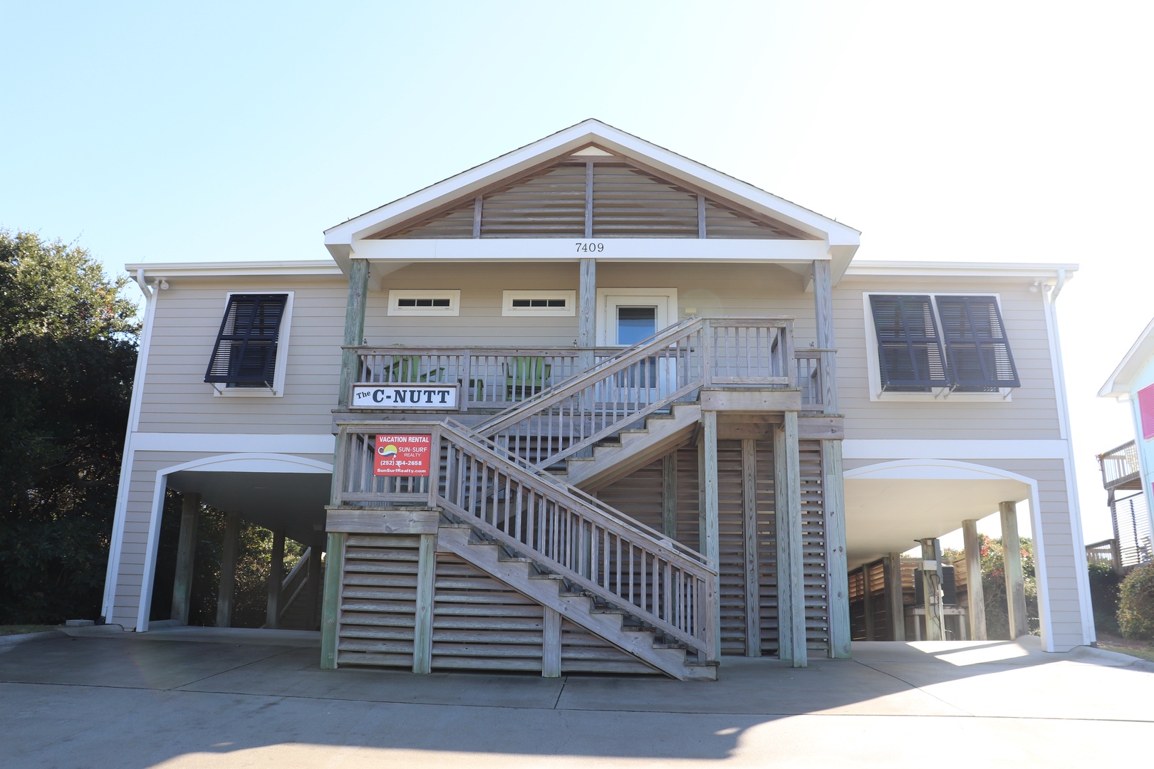 Traditional coastal vacation rental with elevated design and covered parking, located in a peaceful residential area.